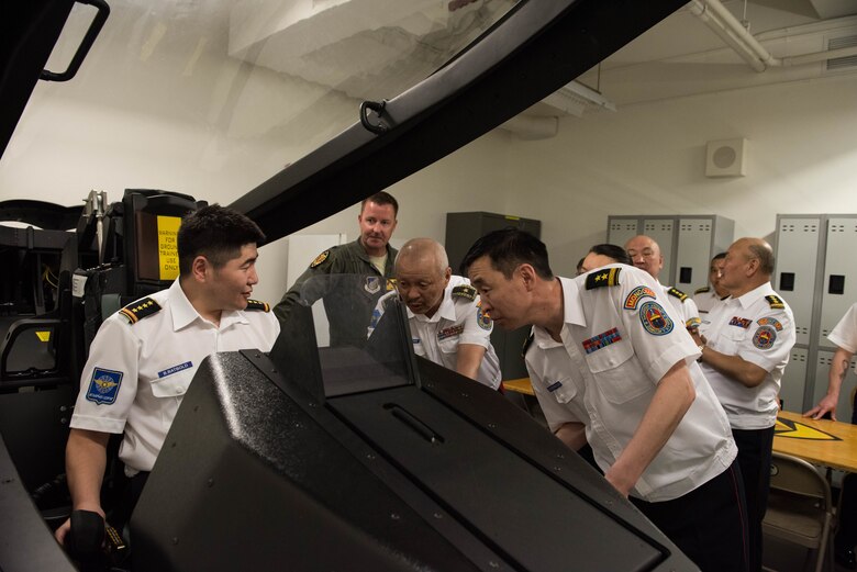Airmen from the Mongolian Air Force Command sit in an F-22 simulator during a visit to the 154th Wing, Hawaii Air National Guard, Joint Base Pearl Harbor-Hickam, Hawaii, March 26, 2019.