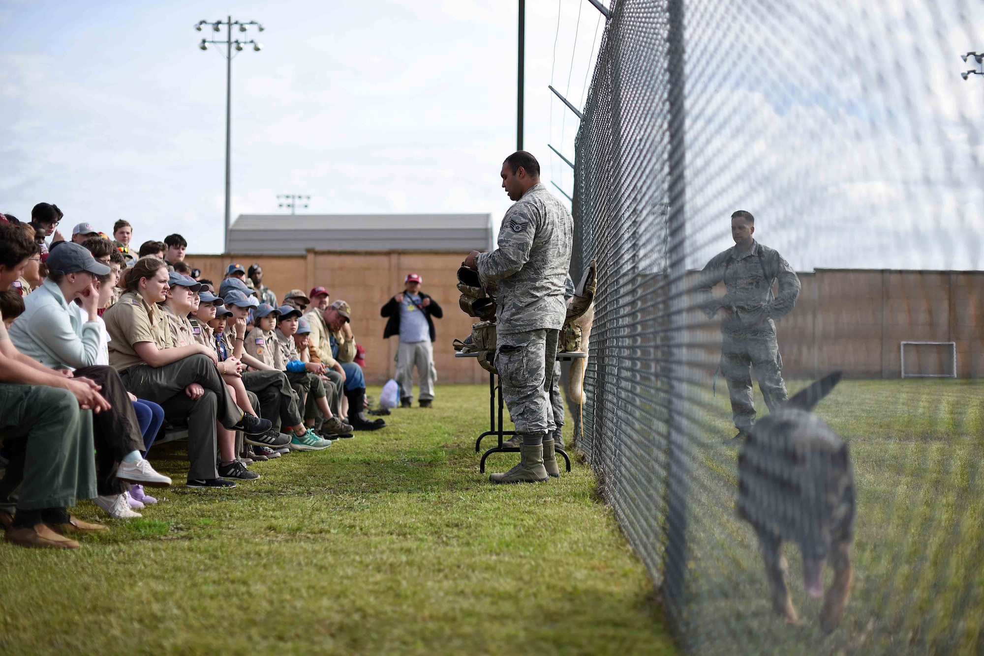 Scouts, Boy Scouts of America members and their parents watch a 14th Security Forces Squadron military working dog demonstration March 30, 2019, on Columbus Air Force Base, Mississippi. The scouts also saw static aircraft, firefighters, air traffic controllers and aerospace and operational physiology flight Airmen in their work facilities. (U.S. Air Force photo by Airman 1st Class Keith Holcomb)