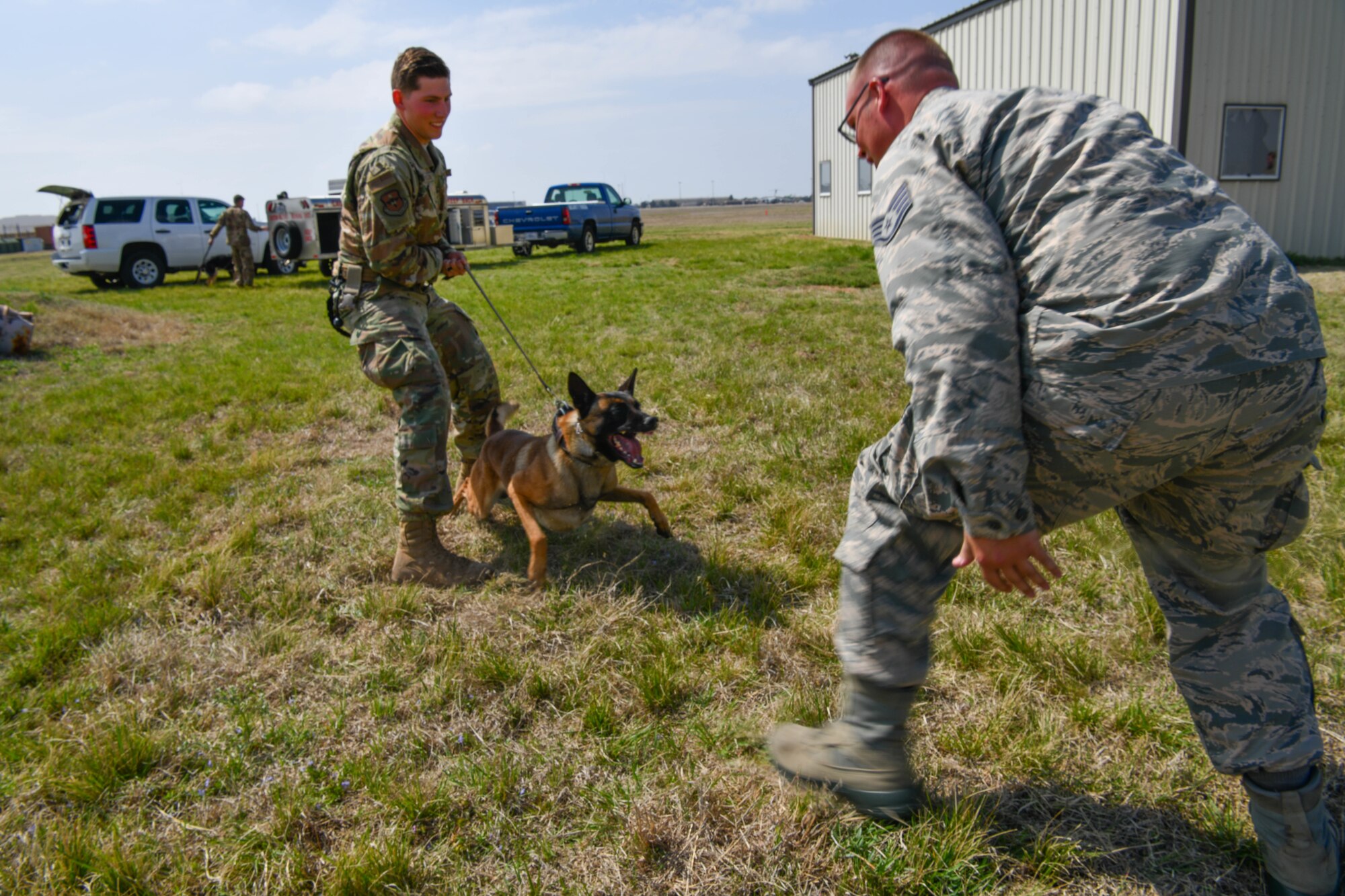 U.S. Air Force Senior Airman Russell Ferguson, dog handler assigned to 97th Security Forces Squadron, holds back his canine from a simulated aggressor, Mar. 29, 2019, at Altus Air Force Base, Okla. Military working dogs are trained daily to learn to encounter threats and dangerous situations.  (U.S. Air Force photo by Airman First Class Dallin Wrye)