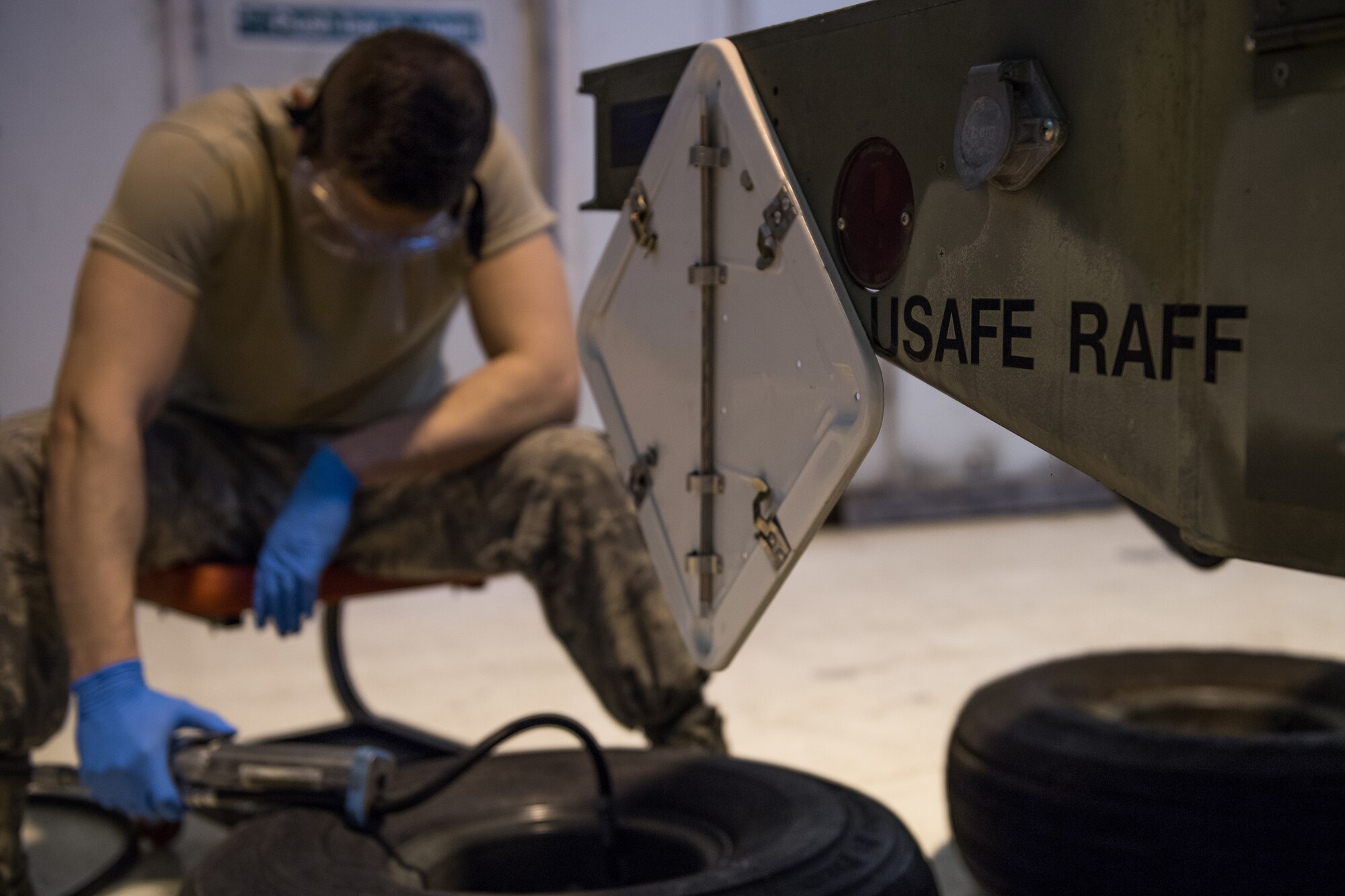 Airman 1st Class Carson Rinaldi, 2nd Munitions Squadron conventional maintenance crew chief, inflates a tire for a MHU-110 munitions trailer at RAF Fairford, England, April 2, 2019. These trailers are used to transport munitions to aircraft. (U.S. Air Force photo by Airman 1st Class Tessa B. Corrick)