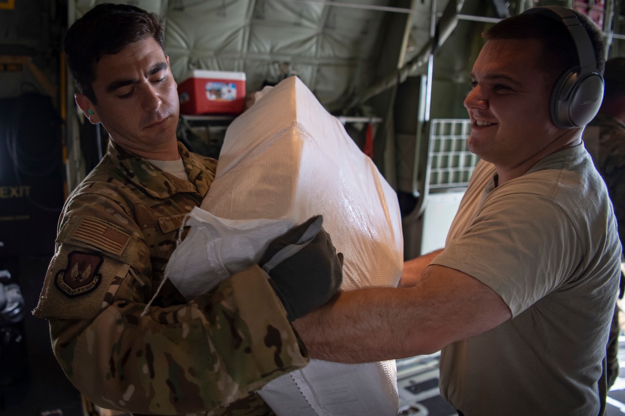 Airmen load food onto and airplane
