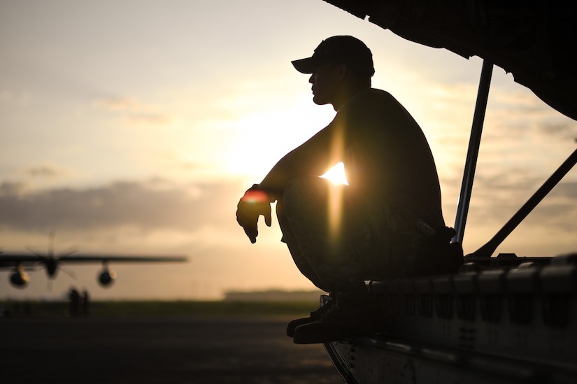 An airman rests on the ramp of an airplane.