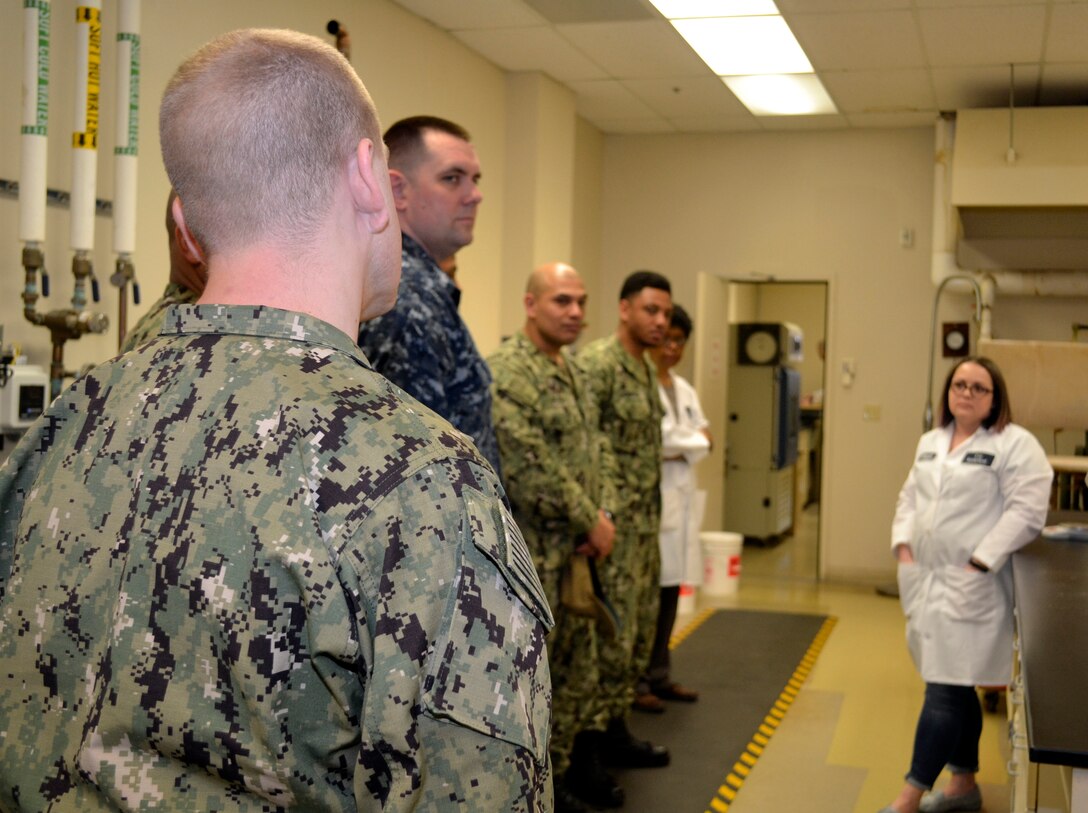 Sailors assigned to Naval Support Activity Philadelphia ask DLA Troop Support Product Test Center Analytical textile technologist Anna Wilson, far right, questions about how to properly care for their uniforms in order to maintain their non-reflective properties to remain battle-ready April 3, 2019 in Philadelphia.