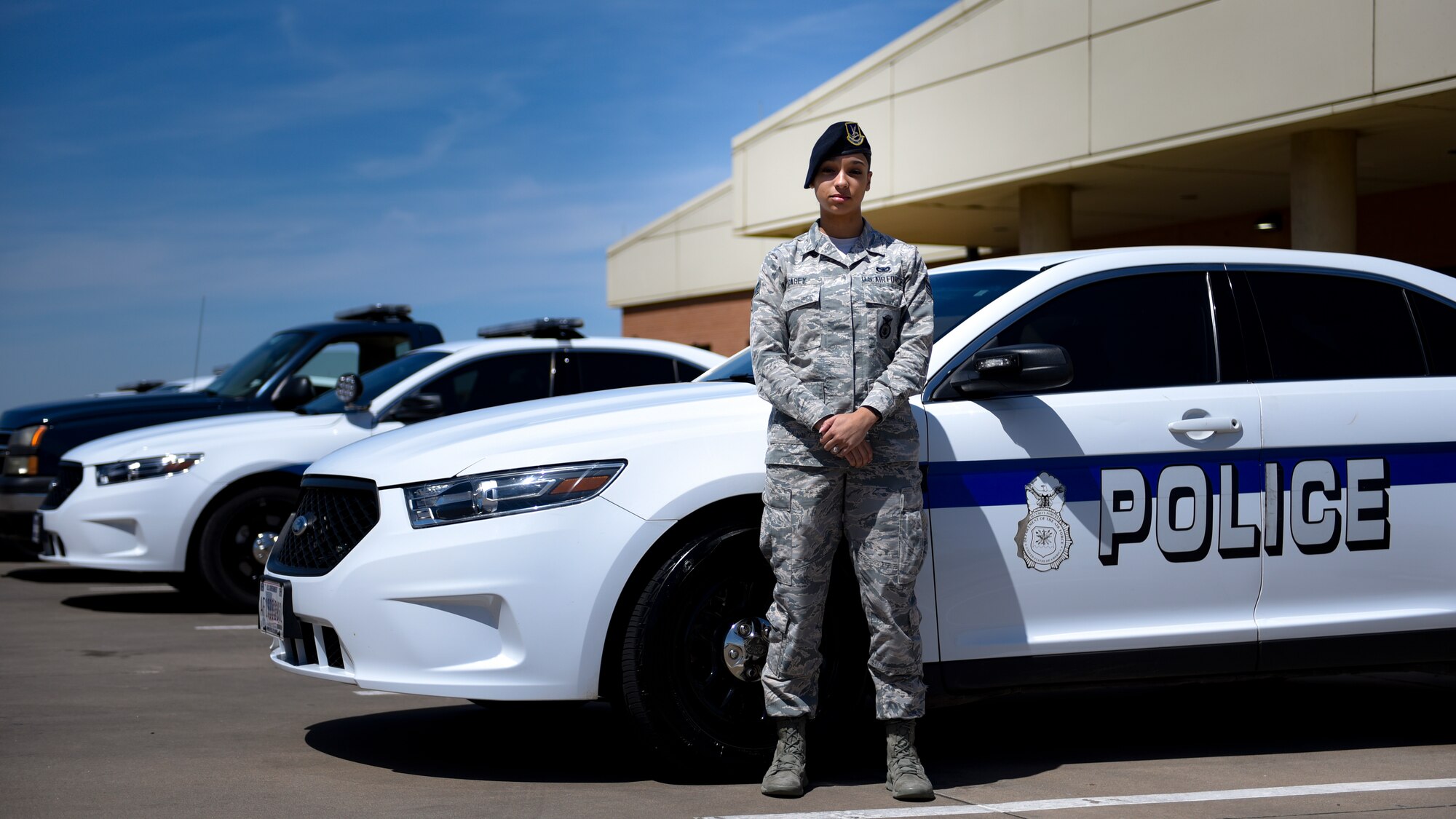 Security Forces Airman poses for a photo in front of her patrol car