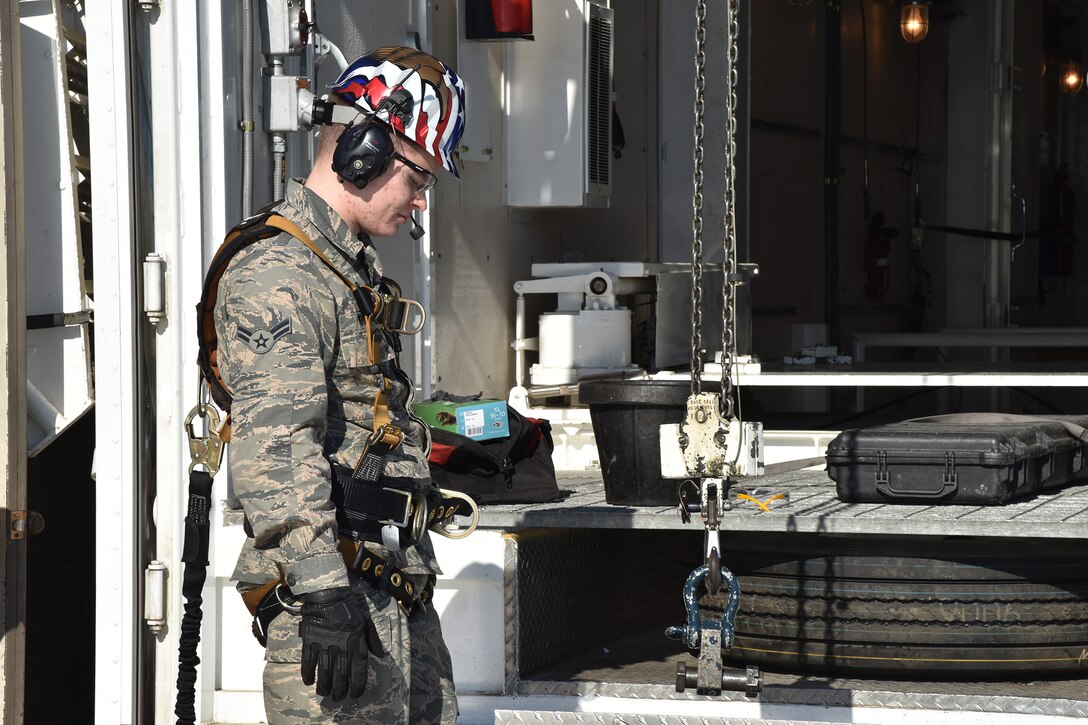 Airman 1st Class Sean Moore, 741st Maintenance Squadron mechanical and pneudraulics section technician, guides down a chain and hoist from a payload transporter to a tensioner March 18, 2019, at Malmstrom Air Force Base, Mont.
