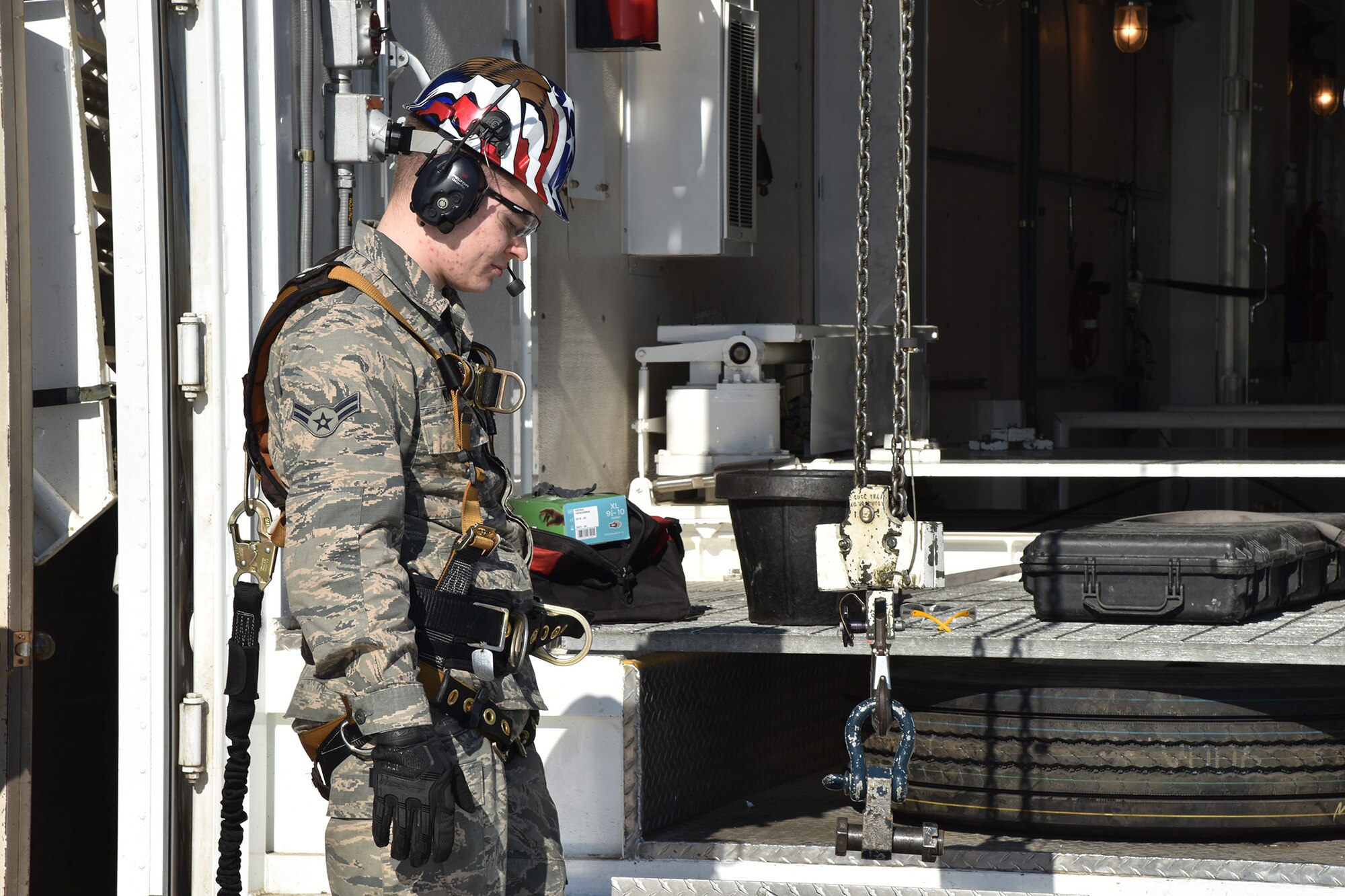 Airman 1st Class Sean Moore, 741st Maintenance Squadron mechanical and pneudraulics section technician, guides down a chain and hoist from a payload transporter to a tensioner March 18, 2019, at Malmstrom Air Force Base, Mont.