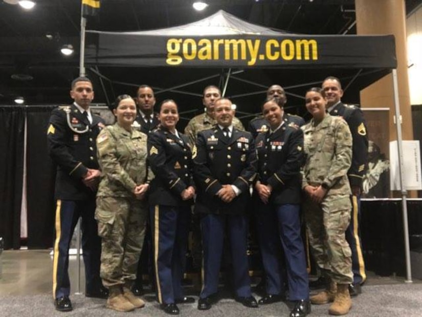 (Pictured Center) Sgt. 1st Class Leonel Castillo, a U.S. Army recruiter with the Kissimmee Recruiting Office, Tampa Recruiting Battalion, 2nd Recruiting Brigade, United States Recruiting Command, and (pictured left of Castillo) Sgt. Von Marie Donato, a Special Recruiter Assistance Program participant and a public affairs specialist assigned to U.S. Army Central, pose for a group photo along with other SRAP participants at the Tom Joyner Family Reunion Convention Show in Orlando, FL at the Gaylord Palms Resort Aug. 31, 2017.