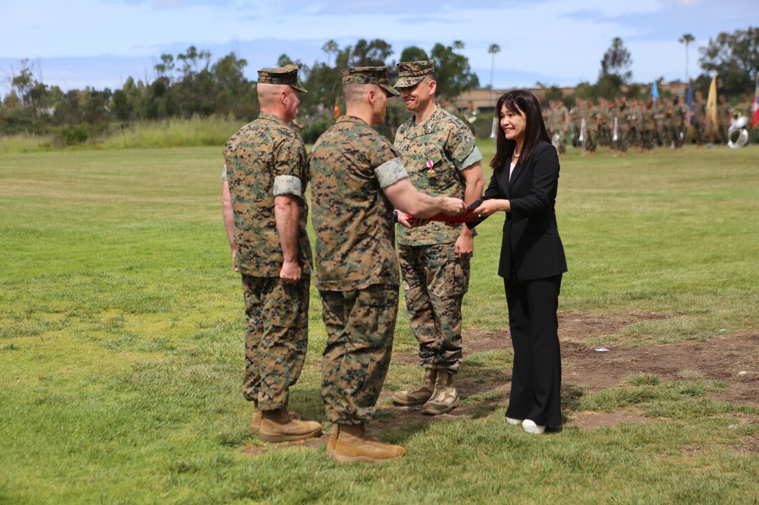 Yoko Stavale, wife of Lt. Col. Giuseppe A. Stavale, former provost marshal for Marine Corps Air Station Miramar (MCAS), receives a Certificate of Commendation for her faithful devotion during her husband’s Marine Corps career during his retirement ceremony at MCAS Miramar, Calif., April 3. Stavale retired after 30 years of honorable and faithful service in the Marine Corps. (U.S. Marine Photo by Lance Cpl. Cheng Chang)