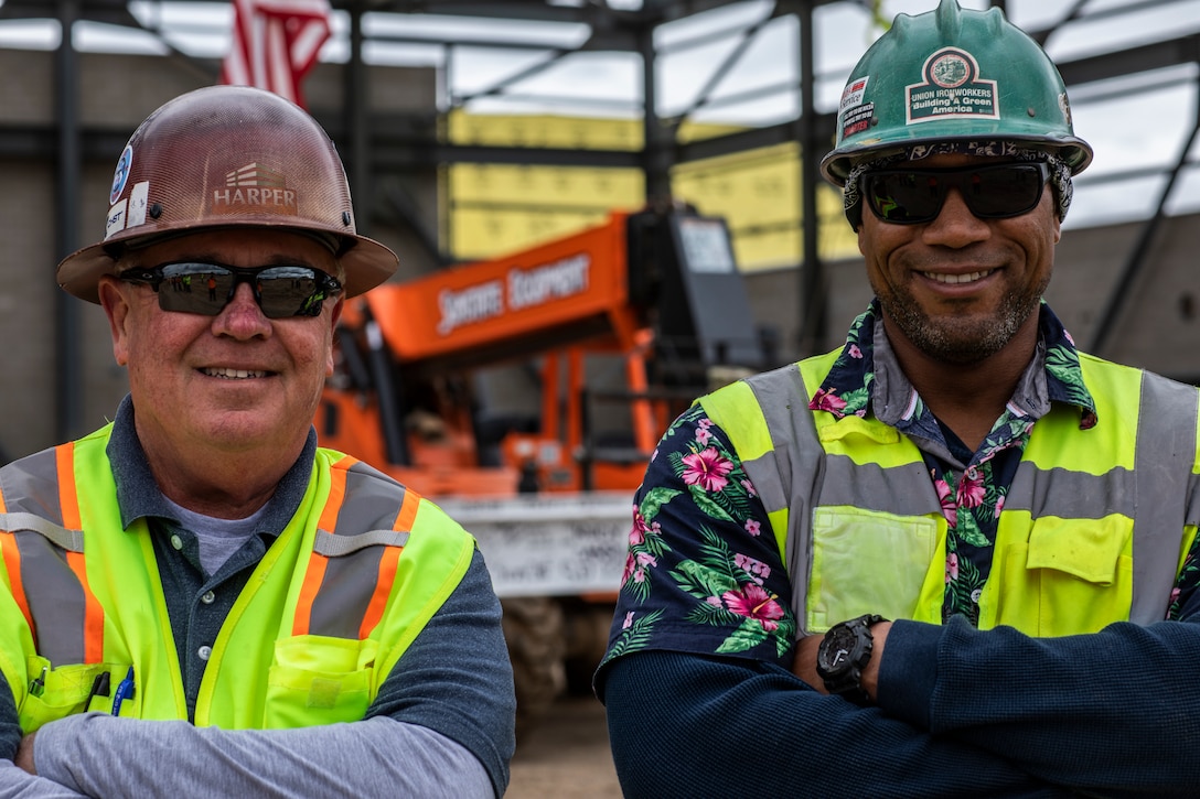 Tim Arnold, left, and Dave Gates, right, safety representatives for the F-35C hangar project, smile for a photo before the final beam is placed on the hangar at Marine Corps Air Station Miramar, Calif., April 4. Key leaders with MCAS Miramar and more than 60 local San Diego construction firms came together to place the last beam on MCAS Miramar’s first  F-35C Hangar during a “topping out” ceremony. (U.S. Marine Corps photo by Sgt. Jake McClung)