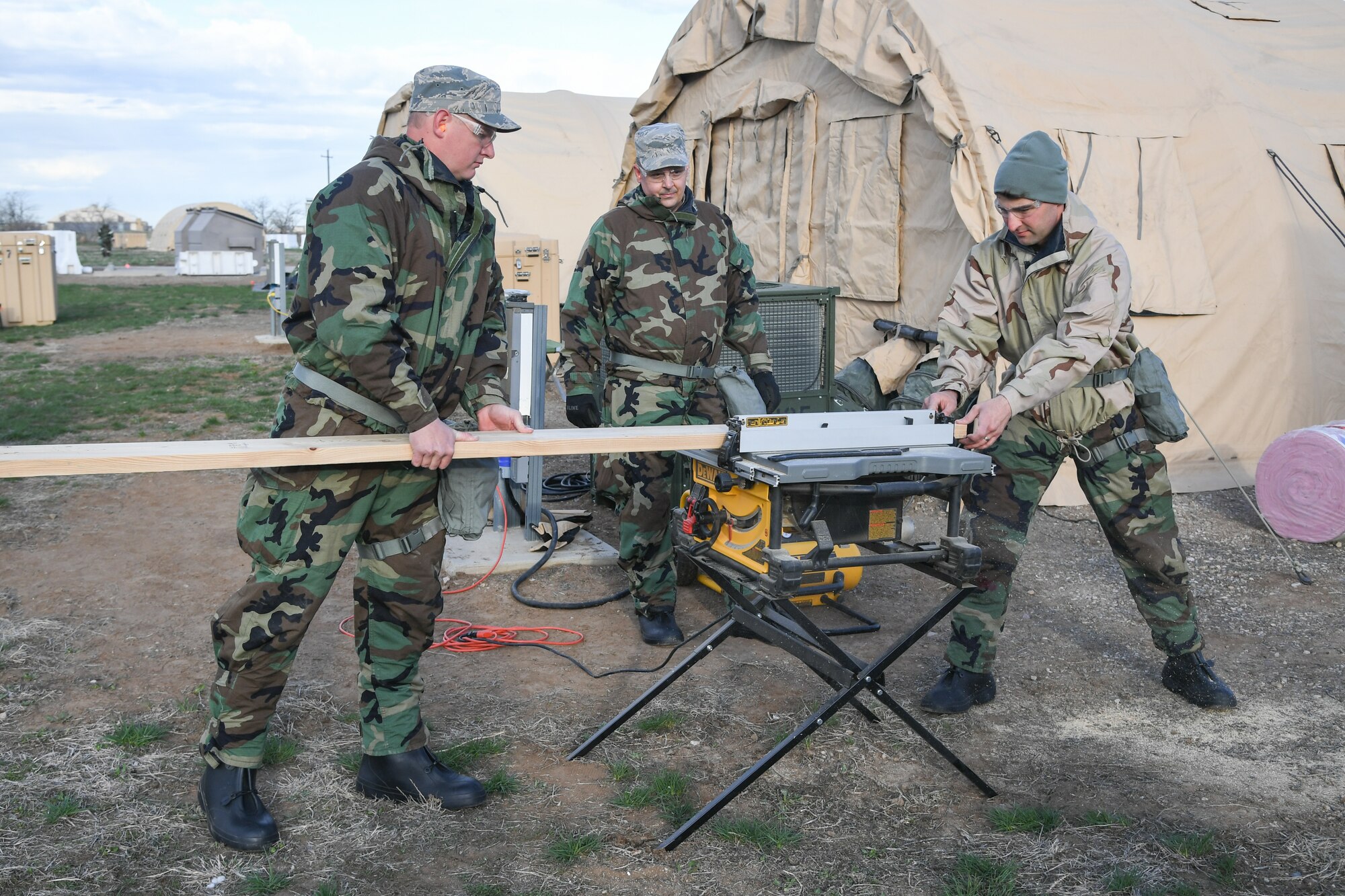 Tech. Sgt. Joshua Jacobson, Tech. Sgt. Timothy Lynch, Staff Sgt. Zachariah Pinkston prepare to build a shed for a firefighting exercise