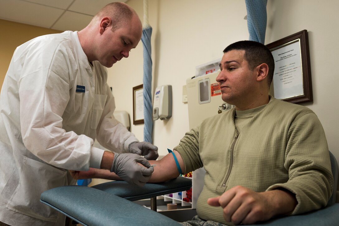 Tech. Sgt. Eathain Duwe, 23d Medical Support Squadron medical laboratory technician, left, prepares to draw blood from Senior Airman Gabriel Jimenez, 23d Aerospace Medicine Squadron public health technician, right, during 'Deployers 1st' Thursday, April 4, 2019, at Moody Air Force Base, Ga. 'Deployers 1st' Thursdays is a program that prioritizes giving deploying Airmen medical clearance faster. (U.S. Air Force photo by Airman 1st Class Hayden Legg)