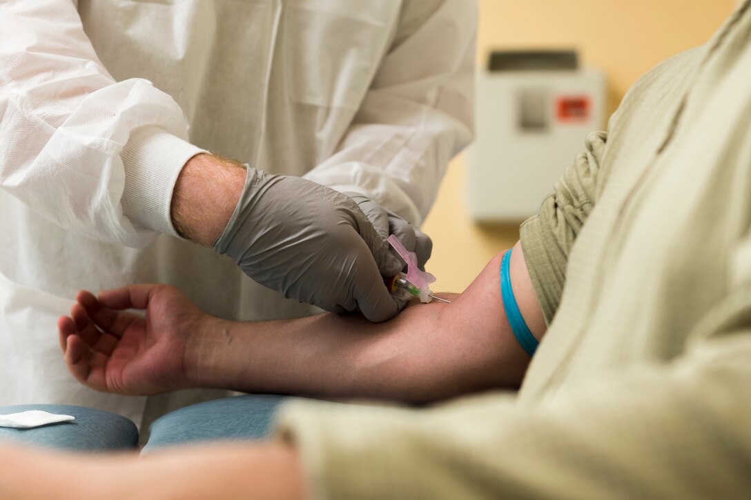 Tech. Sgt. Eathain Duwe, 23d Medical Support Squadron medical laboratory technician, left, draws blood from Senior Airman Gabriel Jimenez, 23d Aerospace Medicine Squadron public health technician, right, during 'Deployers 1st' Thursday, April 4, 2019, at Moody Air Force Base, Ga. 'Deployers 1st' Thursdays is a program that prioritizes giving deploying Airmen medical clearance faster. (U.S. Air Force photo by Airman 1st Class Hayden Legg)