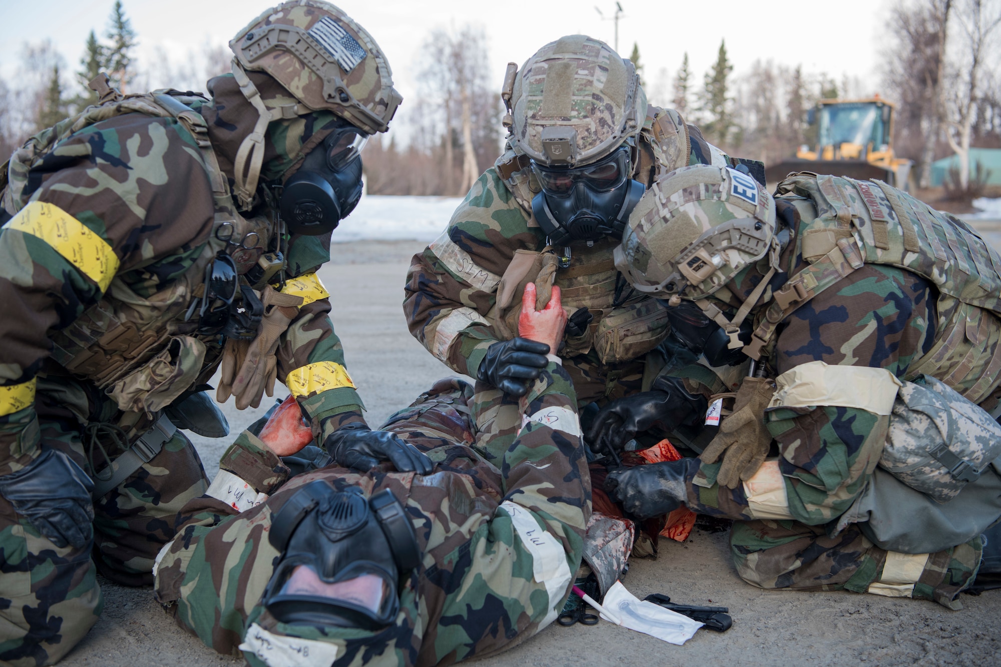 Explosive Ordnance Disposal Airmen conduct self-aide buddy care in a simulated chemical environment during Polar Force 19-4 at Joint Base Elmendorf-Richardson, Alaska, April 4, 2019. Polar Force is a two-week exercise designed to test JBER’s mission readiness and strengthen and develop the skills service members require when facing adverse situations.