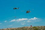Two Black Hawk helicopters, equipped with aerial water buckets, from the Chief Warrant Officer 5 David R. Carter Army Aviation Support Facility at Buckley Air Force Base, Aurora, Colorado, depart the Spring Fire helibase, in Fort Garland, Colorado, to support fire suppression efforts July 3, 2018.  On order of the Governor, the standing Joint Task Force - Centennial commands and integrates CONG forces to support civil authorities in assisting Colorado, or supported states, during times of crisis and disaster, to save lives, prevent suffering, and mitigate great property damage. (U.S. Air National Guard photo by Tech. Sgt. Nicole Manzanares)