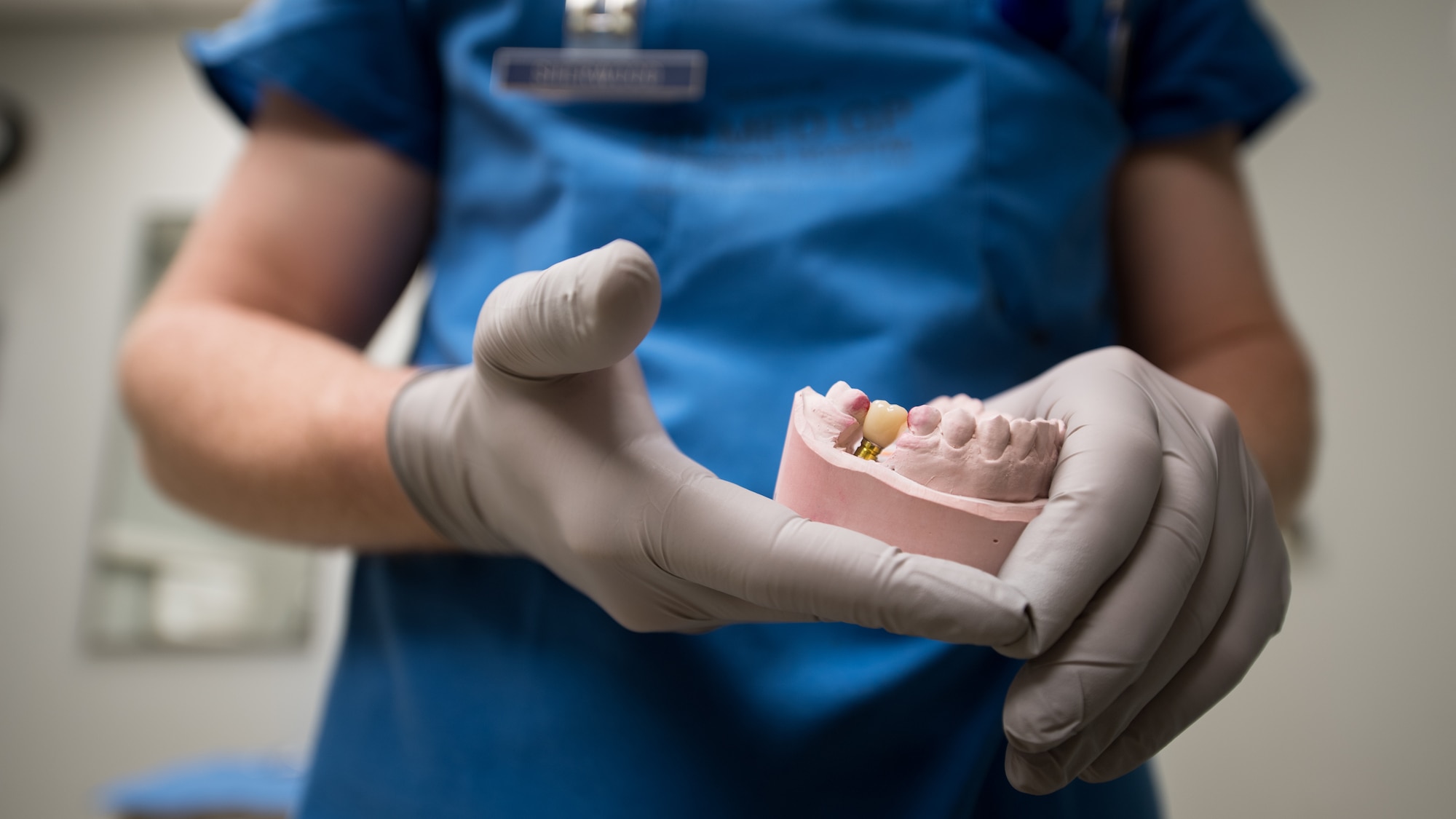 U.S. Air Force Capt. Matthew Sherwood, 2nd Dental Squadron dental resident, uses a cast dental impression to demonstrate how a prosthetic tooth will replace the right mandibular second molar and align with the other teeth of the lower jaw at the Barksdale Dental Clinic, Louisiana, April 4, 2019. Dental implants consist of a surgically implanted metal post in the jaw, an abutment that serves as an extension of the post, and the prosthetic tooth and attaches to the abutment piece. (U.S. Air Force photo by Tech. Sgt. Daniel Martinez)