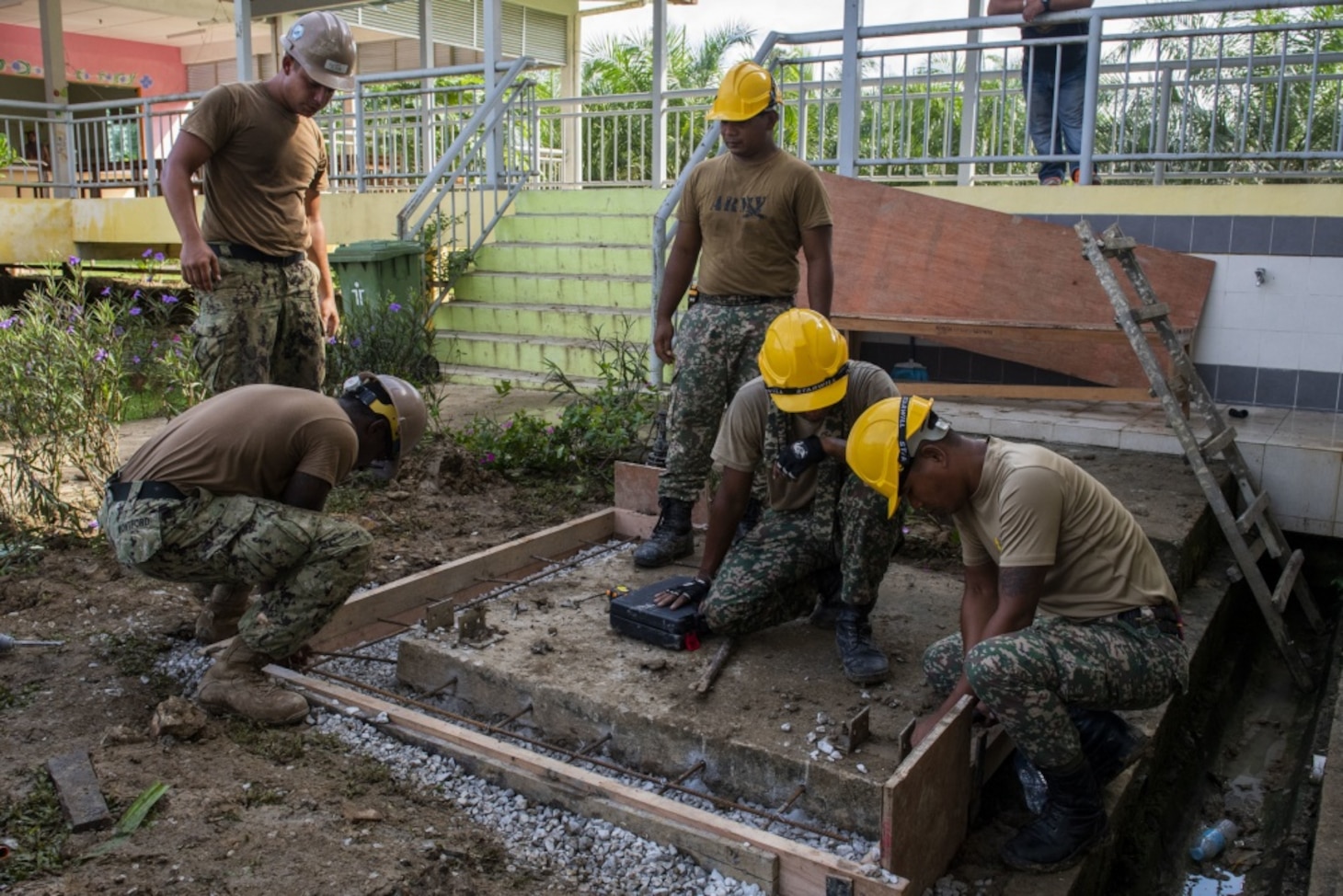 KUCHING, Malaysia (April 5, 2019) – Malaysian Armed Forces and U.S. Navy Seabees place rebar in a concrete footing as part of a Pacific Partnership 2019 water tank restoration project at Tanah Puteh Elementary School. Pacific Partnership, now in its 14th iteration, is the largest annual multinational humanitarian assistance and disaster relief preparedness mission conducted in the Indo-Pacific. Each year the mission team works collectively with host and partner nations to enhance regional interoperability and disaster response capabilities, increase security and stability in the region, and foster new and enduring friendships in the Indo-Pacific. (U.S. Navy photo by Mass Communication Specialist 1st Class Nathan Carpenter)