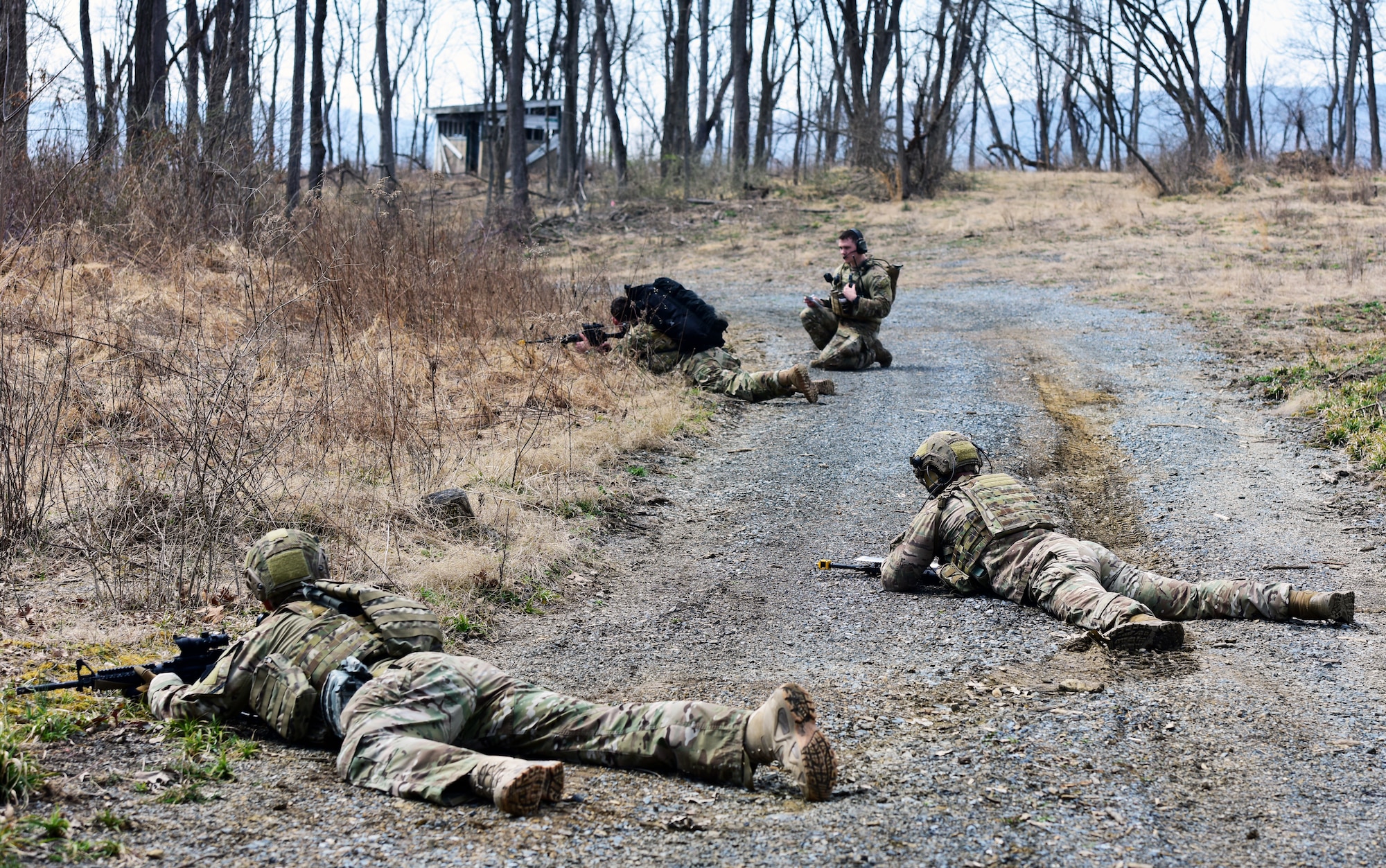 Airmen of the 148th Air Support Operations Squadron, 193rd Special Operations Wing, lay on the ground to take cover from simulated enemy fire during a Tactical Combat Casualty Care field training exercise April 6, 2019, at Fort Indiantown Gap, Annville, Pennsylvania. Airmen participating in the FTX completed three different timed scenarios in which they moved tactically through a series of unpredicted “ambushes” to provide simulated medical care for casualties. (U.S. Air National Guard photo by Staff Sgt. Rachel Loftis)