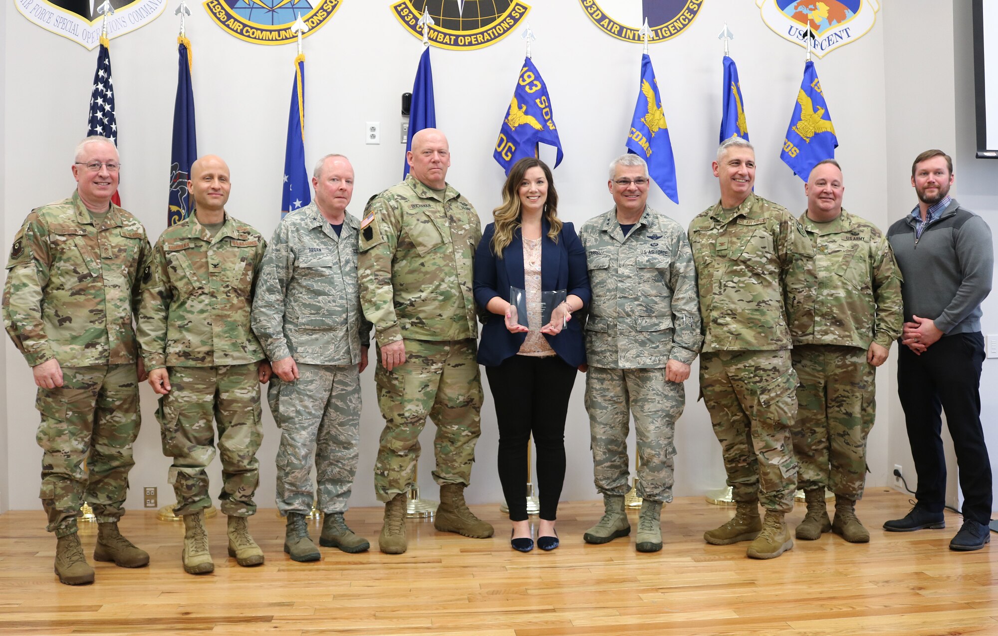 In a ceremony April 6, 2019, Family Readiness volunteer Renee Kotch (center) is named 2018 Region 3 Volunteer of the Year at the 193rd Air Operations Group, State College, Pennsylvania. Maj. Gen. Tony Carrelli (right of Kotch), adjutant general, Pennsylvania National Guard, and other distiguished visitors, attended the event to congratulate Kotch on her efforts to provide support and resources to the families of the AOG. “There is so much pride within this volunteer community. My advice to servicemembers: Don’t assume your spouse doesn’t want to be involved. Let us take the same passion, pride and patriotism we all share in our hearts and allow us - the family members - to serve, too,” Kotch said. (U.S. Air National Guard photo by Tech. Sgt. Denise Mckee)