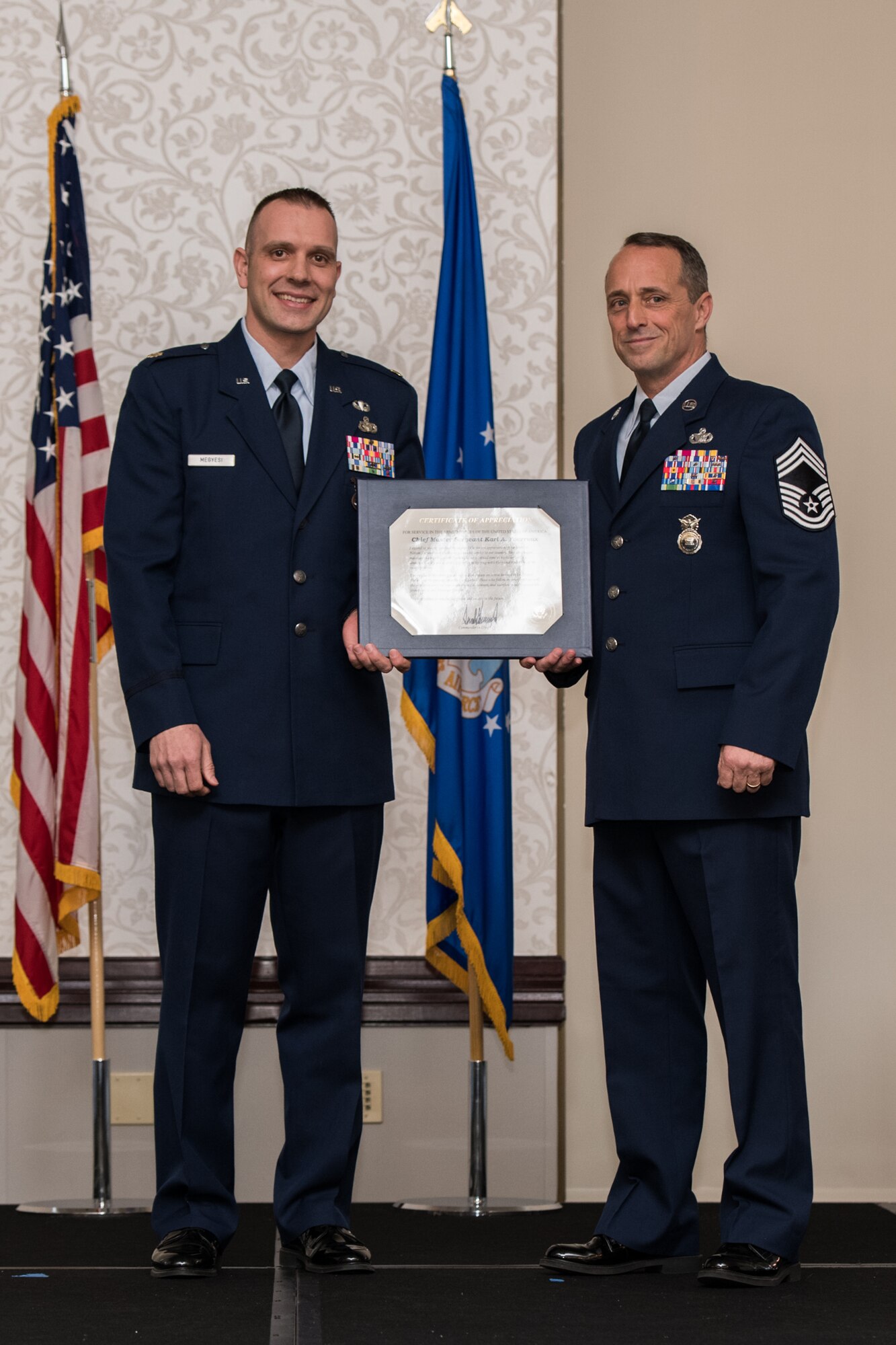U.S. Air Force Maj. Nicolas Megyesi, left, presents Chief Master Sgt. Karl Fourroux, security forces manager, 932nd Airlift Wing, the certificate of retirement at his retirement ceremony on April 6, 2019, Scott Air Force Base, Illinois. Citizen Airmen Chief Fourroux retired after honorably serving for 34 years.  (U.S. Air Force photo by Senior Airman Brooke Deiters)