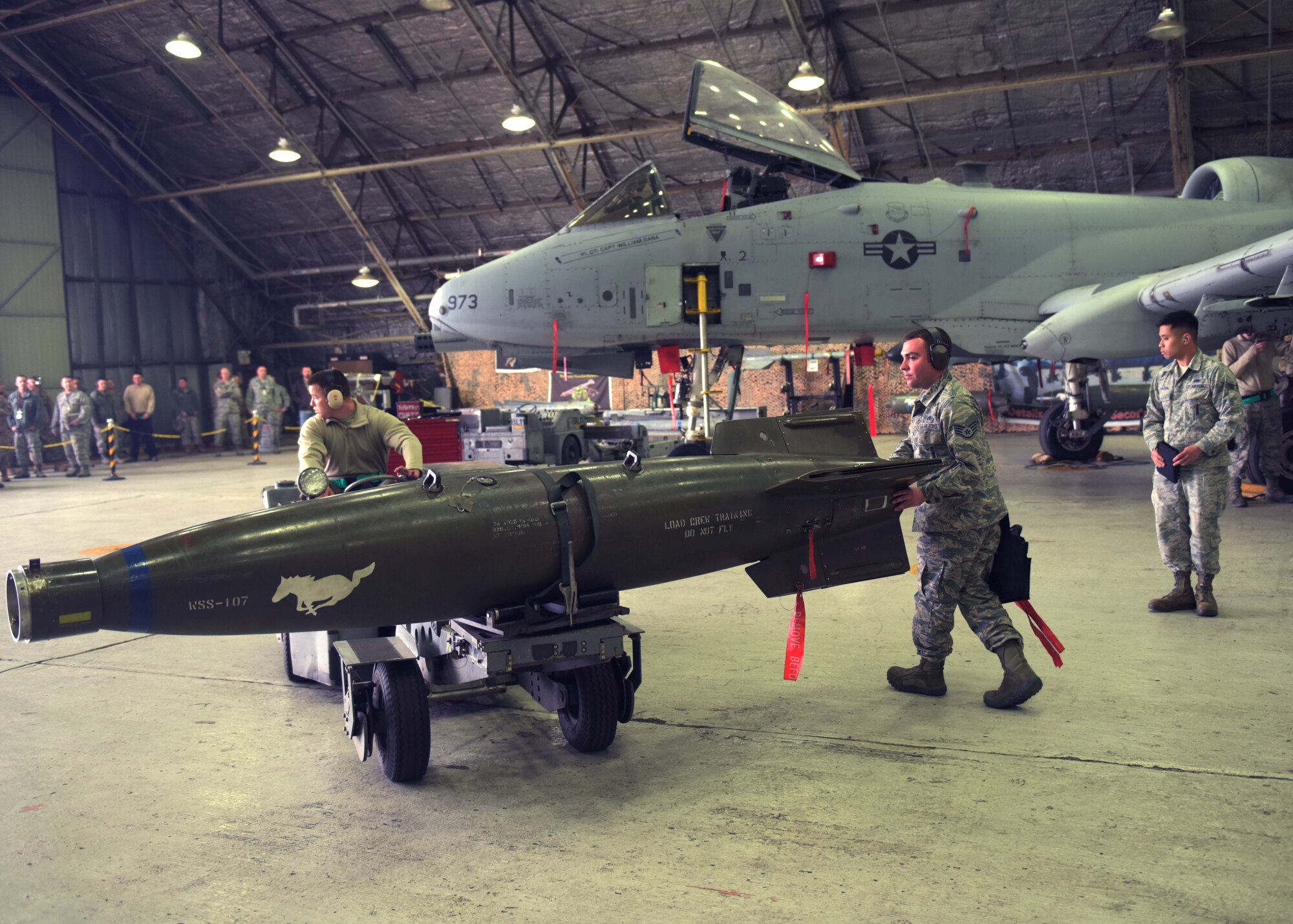 U.S. Air Force Senior Airman Dylan Raines (left), a weapons load crew team member, and Staff Sgt. Peter Discipio, a weapons load crew team chief, both assigned to the 51st Aircraft Maintenance Squadron, prepare to load a munition onto an A-10 Thunderbolt II during a weapons load crew competition at Osan Air Base, Republic of Korea, April 5, 2019. Weapons load crew competitions test a squadron’s ability to safely and accurately load munitions onto their respective aircraft. (U.S. Air Force Photo by Staff Sgt. Timothy Dischinat)
