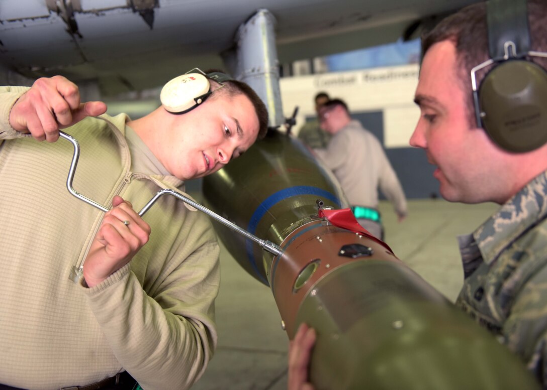 U.S. Air Force Senior Airman Dylan Raines, a weapons load crew team member, works with Staff Sgt. Peter Discipio, a weapons load crew team chief, both assigned to the 51st Aircraft Maintenance Squadron, as they prepare a munition during a weapons load crew competition at Osan Air Base, April 5, 2019. Weapon load crew competition test a squadron’s ability to safely and accurately load munitions into their respective aircrafts. (U.S. Air Force Photo by Staff Sgt. Timothy Dischinat)