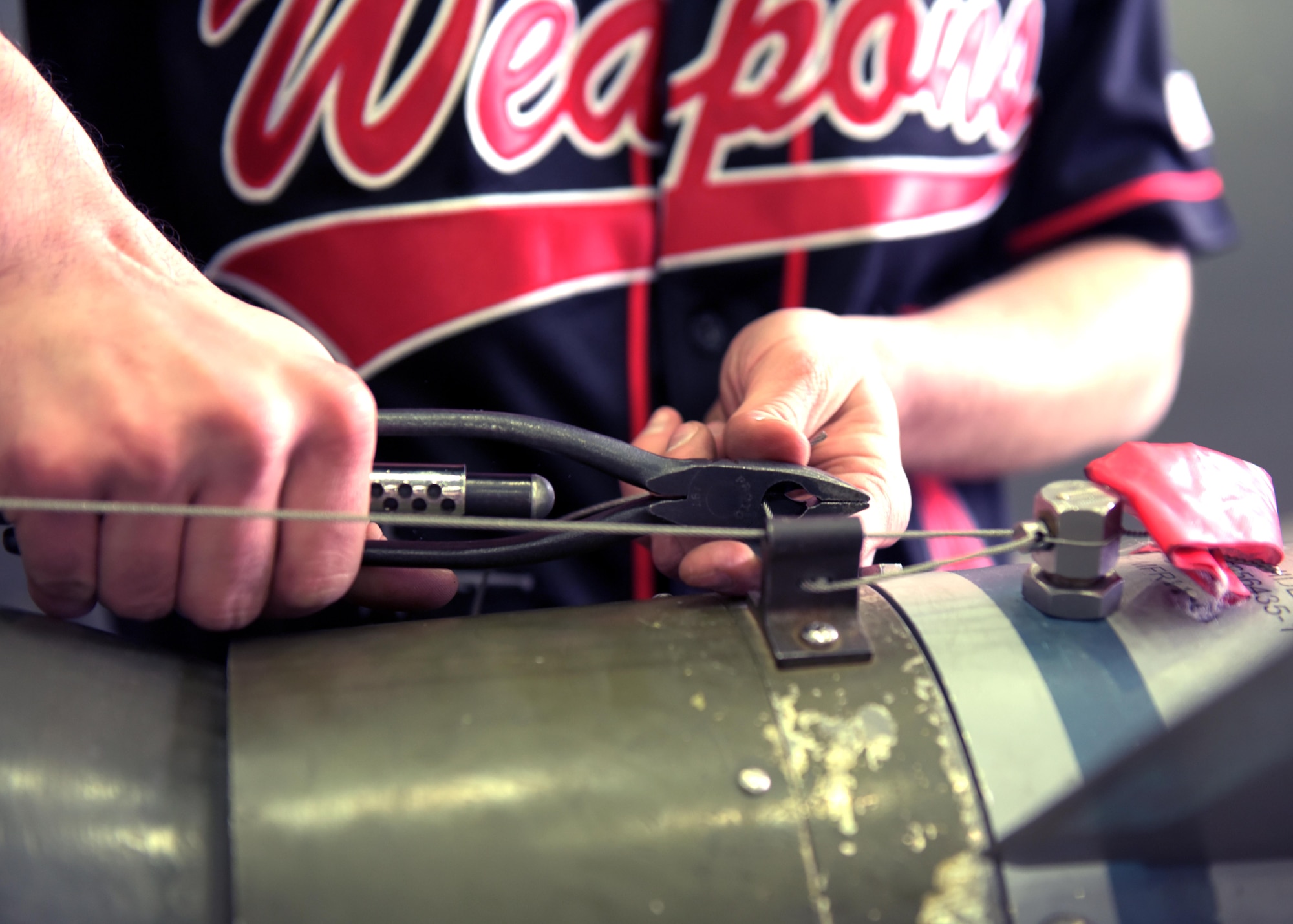 U.S. Air Force Senior Airman Samuel Guimond, a weapons load crew team member assigned to the 51st Aircraft Maintenance Squadron, snips a fuse wire on a munition during a weapons load crew competition at Osan Air Base, April 5, 2019. Weapons load crew competitions test a squadron’s ability to safely and accurately load munitions onto their respective aircrafts. (U.S. Air Force Photo by Staff Sgt. Timothy Dischinat)