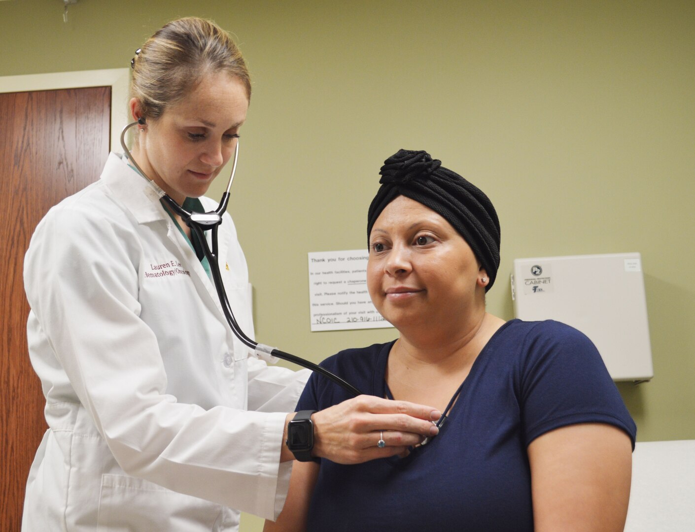 Air Force Capt. (Dr.) Lauren Lee examines Faunia Rodriguez at the Brooke Army Medical Center Hematology/Oncology Clinic Nov. 6, 2018.