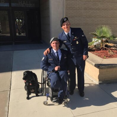 Airman 1st Class Grant Morgan, 82nd Security Forces Squadron entry controller, poses with his father, retired special operations weatherman Staff Sgt. Jason Morgan, and his service dog. Jason Morgan had visited Sheppard Air Force Base, Texas, where he did a book signing for his new book. (U.S. Courtesy Photo)