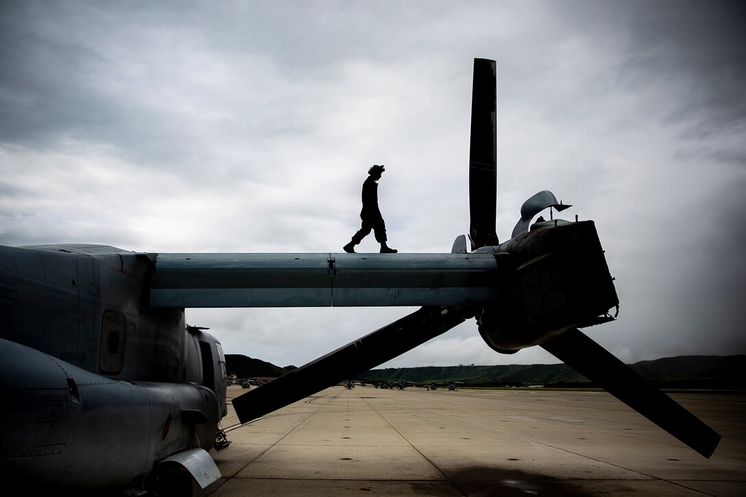 An Airman walks across the wing of an aircraft.