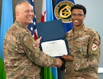 Air Force Col. Kjäll Gopaul (left), communications director for Combined Joint Task Force-Horn of Africa (CJTF-HOA), presents a U.S. Navy enlisted information warfare specialist (EIWS) certificate to Air Force Staff Sgt. Brittany Eley, Joint Network Control Center team lead assigned to CJTF-HOA, at Camp Lemonnier, Djibouti, April 1. Eley has been recognized as the first sister-service EIWS in CJTF-HOA, which signifies that an eligible Sailor has achieved a level of excellence and proficiency in their rating.