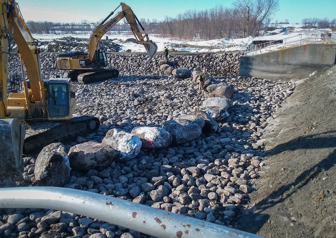 Backhoes do construction on fish passage at dam site