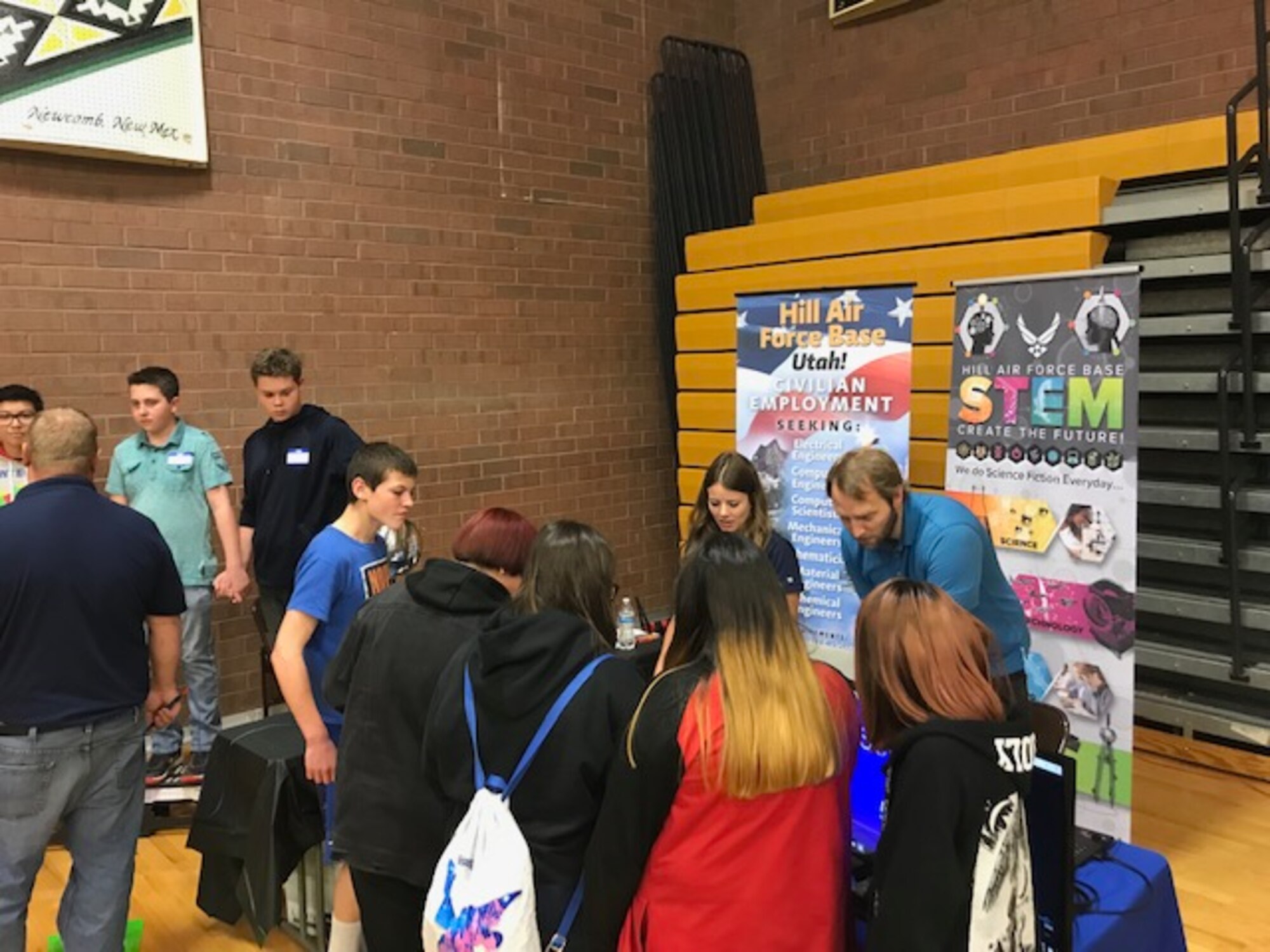 Students at Monument Valley High School in Kayenta, Utah, watch Hill Air Force Base electrical engineer Kristen Keyes and computer scientist Tyler Shilling conduct an experiment during the San Juan Career Fair March 27, 2019. Hill AFB computer scientists and engineers presented the electricity demonstration, taught some basic coding skills and encouraged students to focus on STEM-related subjects, giving them an idea of the important work they could do if they chose an Air Force career. (Courtesy photo)