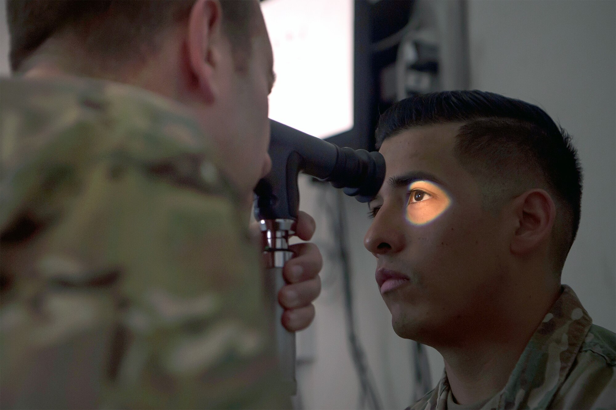 Air Force Lt. Col. Peter Carra (left), 379th Expeditionary Medical Group optometry officer in charge, performs an eye exam for a U.S. Soldier March 9 at Camp As Sayliyah (CAS), Qatar. Carra and Tech. Sgt. Marquita Moore, 379th EMDG optometry NCO in charge, travel to CAS once a week to provide eye care for Soldiers who, in turn, fabricate glasses prescribed for Airmen at Al Udeid Air Base, Qatar, and servicemembers at other deployed locations throughout U.S. Central Command.