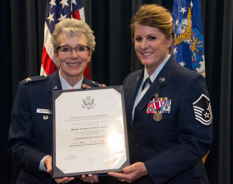 Retired Air Force Col. Betty Bullington presents a certificate of retirement to Master Sgt. Kim Coates, 39th Aerial Port Squadron, during her retirement ceremony at Peterson Air Force Base, Colorado, March 29, 2019.