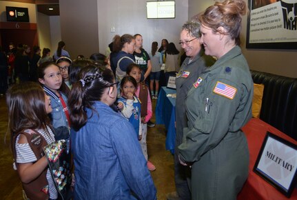 Tech. Sgt. Debra Harper (left), 68th Airlift Squadron loadmaster, and Lt. Col. Kari Hill, 433rd Operations Support Squadron commander/pilot, talk to girls at the “Marvelous Women Don’t Need Capes” event in the lobby of the Alamo Drafthouse movie cinema, March 23, 2019. The “Show them Everything Possible” Organization of San Antonio hosted the event.