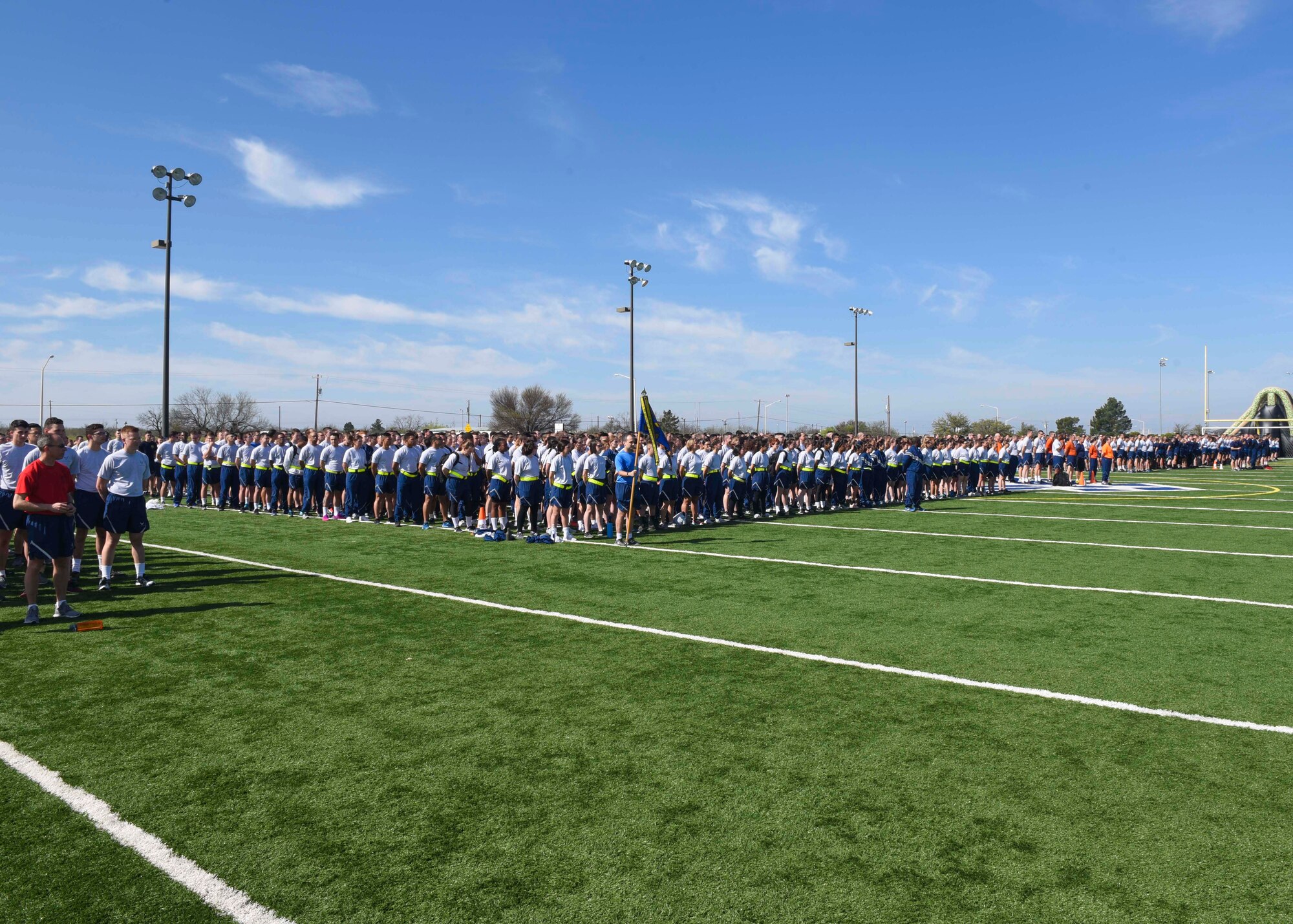 The attending squadrons stand in formation before Sports Day begins at the Mathis Fitness Center, Goodfellow Air Force Base, Texas, April 5, 2019. Groups were able to participate in events such as Ultimate Frisbee, basketball, kickball, volleyball and a firetruck pull. (U.S. Air Force photo by Airman 1st Class Zachary Chapman/Released)