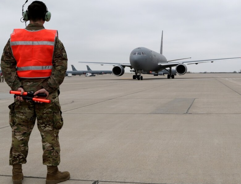 A Tech Sgt. Kurtis Woltemath, 931st Aircraft Maintenance Squadron crew chief, waits to begin marshaling the KC-46A Pegasus flown by Col. Mark Baran, 22nd Air Refueling Wing vice commander, for the first ever KC-46A Total Force formation flight between the 22 ARW and the 931st Air Refueling Wing April 6, 2019, at McConnell Air Force Base, Kan. The commanders of the 22 ARW and 931 ARW flew the Total Force formation. Col. Phil Heseltine, 931 ARW commander, flew another KC-46 in the formation.
