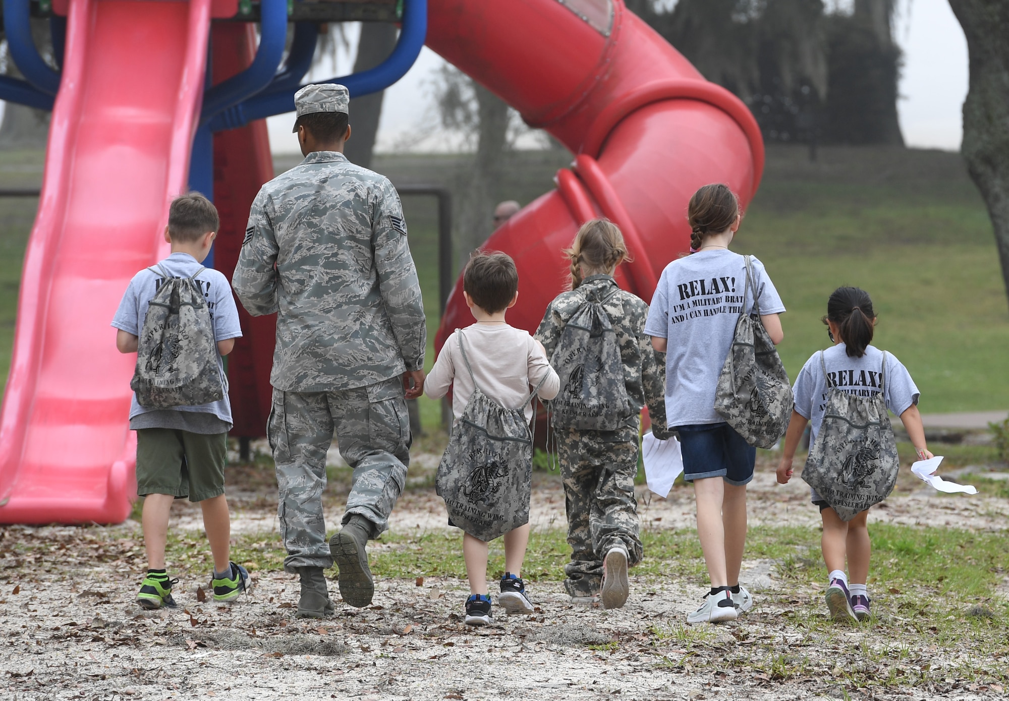 Military children are escorted to the next check list item during Operation Hero at Keesler Air Force Base, Mississippi, April 6, 2019. The event, hosted by the Airman and Family Readiness Center in recognition of the Month of the Military Child, gave military children a glimpse into the lives of deployed military members. Children received Operation Hero dog tags and t-shirts as they made their way through the mock deployment line as well as the opportunity to experience medical triage demonstrations, gas mask training and have their faces painted. (U.S. Air Force photo by Kemberly Groue)