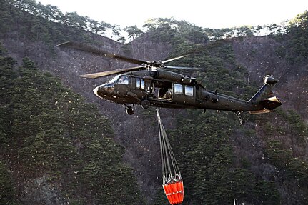 GANGWON, Republic of Korea – A UH-60 Black Hawk helicopter crew with 2-2 Assault Helicopter Battalion, 2nd Combat Aviation Brigade, 2nd Infantry Division/ROK-U.S. Combined Division, uses a Bambi bucket to drop water on the wildfire from the air in efforts to extinguish the blaze at Gangwon province, April 5. The effort is in partnership with Republic of Korea Army III Corps Command and other local agencies. (Courtesy photo by Republic of Korea Army Public Affairs)