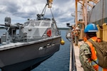 SANTA RITA, Guam (April 4, 2019) Sailors assigned to Navy Cargo Handling Battalion (NCHB) 1, Det. Guam, lift a Mark VI patrol boat assigned to Coastal Riverine Squadron (CRS) 2, Det. Guam, during a first-time proof of concept lift operation aboard the Military Sealift Command maritime prepositioning force ship USNS 2nd Lt. John P. Bobo (T-AK 3008). NCHB-1, Detachment Guam, assigned to Commander, Task Force 75, is the Navy's only active duty cargo handling battalion. They are a rapidly deployable unit of the Navy Expeditionary Combat Command, capable of loading and discharging ships and aircraft in all-climatic and threat conditions. (U.S. Navy photo by Mass Communication Specialist 2nd Class Jasen Moreno-Garcia/Released)