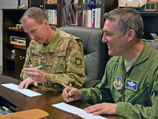 Maj. Gen. Shaun Morris, Air Force Nuclear Weapons Center commander, left, and Brig. Gen. Paul Knapp, his new mobilization assistant, sign their Air Force Assistance Fund pledge forms April 8, 2019. The two signed their forms in Morris’ office to help the center kick off 2019 AFAF campaign. The fund supports the Air Force Aid Society, Air Force Villages Charitable Foundation, Air Force Enlisted Villages, and the LeMay Foundation. As of April 4, center members have donated more than $1,800. The national campaign runs through April 26 (local campaigns may run longer). Contact your unit representative or visit www.afassistancefund.org to make a donation. (Air Force photo by 2nd Lt. Mackenzie Lerum)