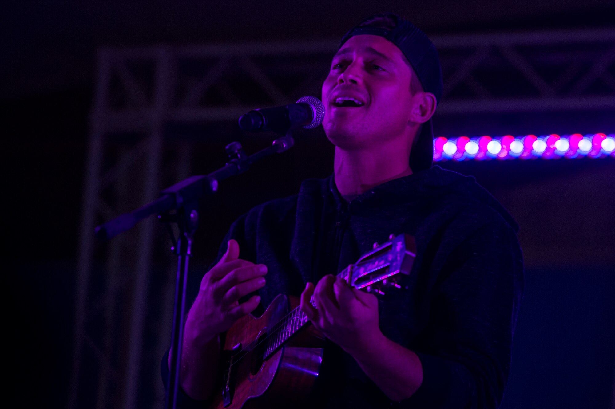 Makua Rothman, professional surfer, sings for service members during the United Service Organizations (USO) tour April 1, 2019, at Al Udeid Air Base, Qatar. U.S. Air Force Gen. Paul Selva, the Vice Chairman of the Joint Chiefs of Staff, hosted the tour alongside celebrities and performers including Robert Irvine, Craig Morgan, and professional athletes.
