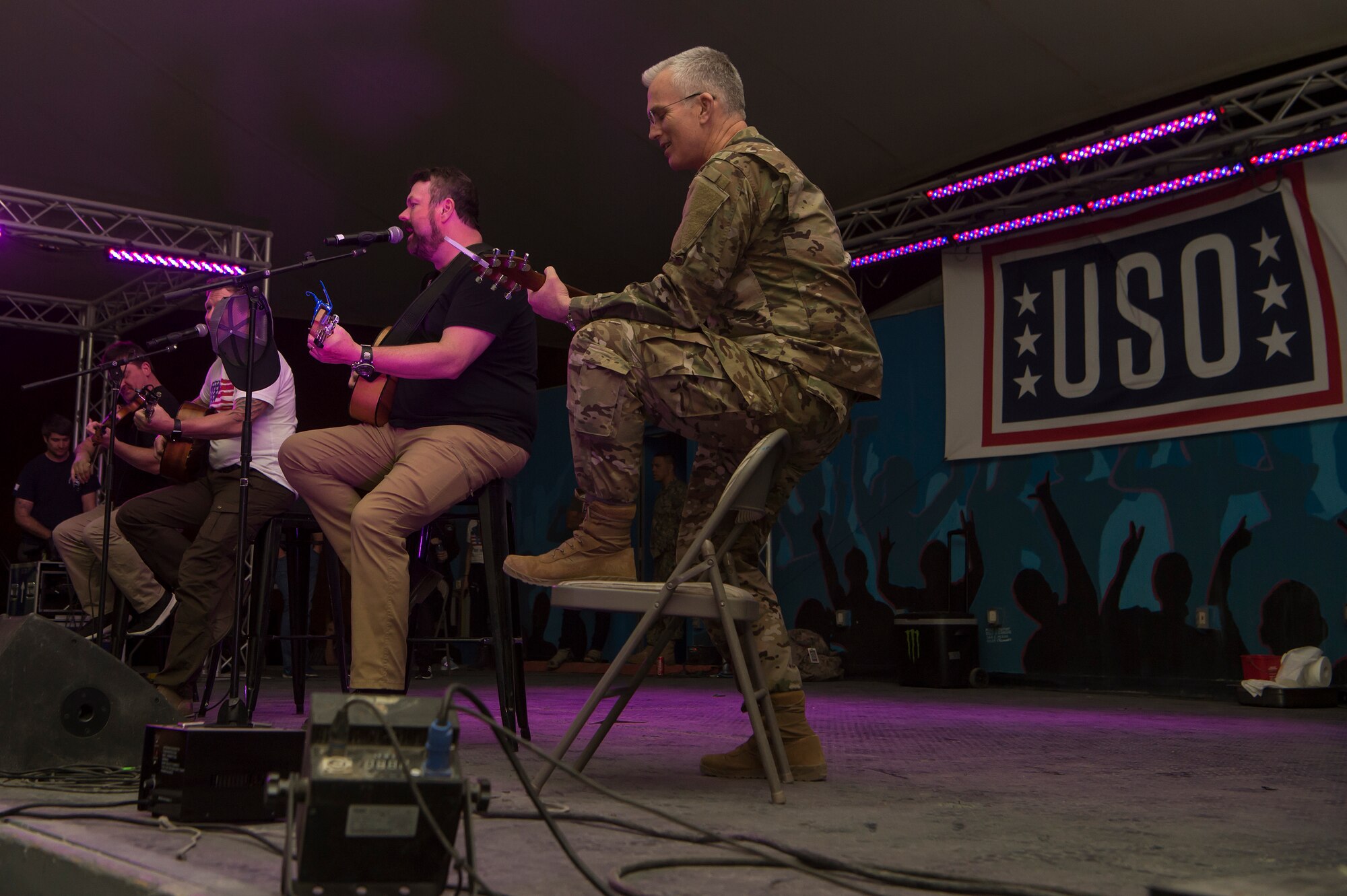 U.S. Air Force Gen. Paul Selva, center, Vice Chairman of the Joint Chiefs of Staff, performs with Craig Morgan, country music singer and songwriter, during the United Service Organizations (USO) tour April 1, 2019, at Al Udeid Air Base, Qatar. Selva hosted the tour alongside celebrities and performers including Morgan, Robert Irvine, and professional athletes. Each year the USO produces more than 50 entertainment tours, bringing hundreds of individual shows to American service members around the world.