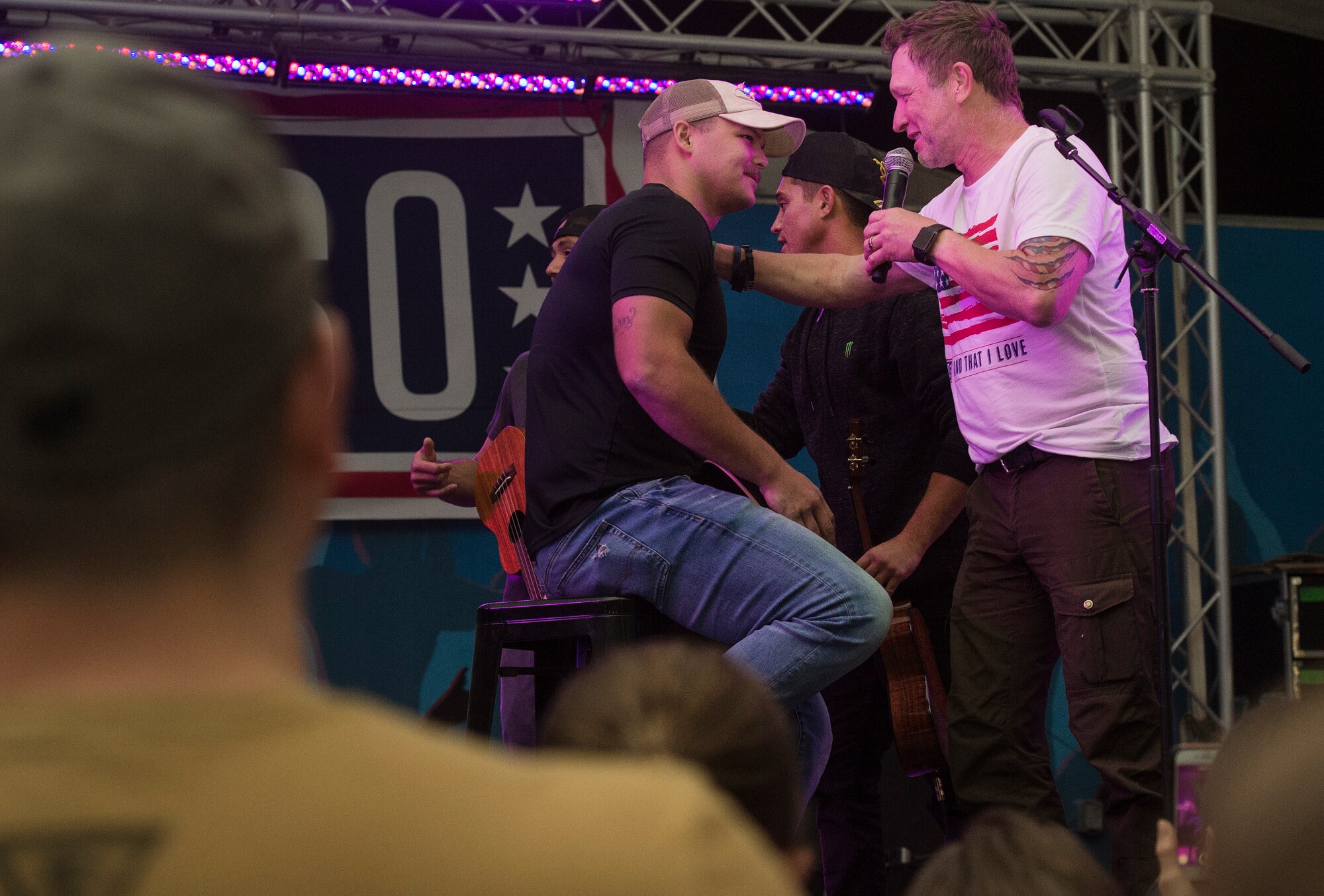 Craig Morgan, right, country music singer and songwriter, thanks a service member for performing a song with him during the United Service Organizations (USO) tour April 1, 2019, at Al Udeid Air Base, Qatar. U.S. Air Force Gen. Paul Selva, Vice Chairman of the Joint Chiefs of Staff, hosted the tour alongside celebrities and performers including Robert Irvine, Craig Morgan, and professional athletes.