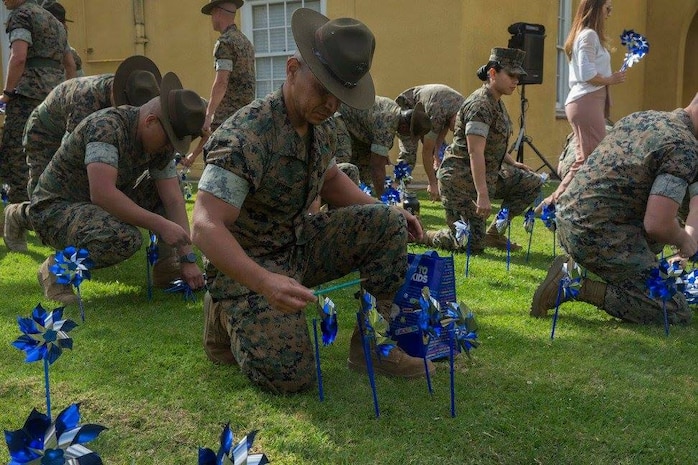 A drill instructor from Marine Corps Recruit Depot San Diego places pinwheels in a garden area during the Pinwheel Garden Event at MCRD San Diego, April 2.