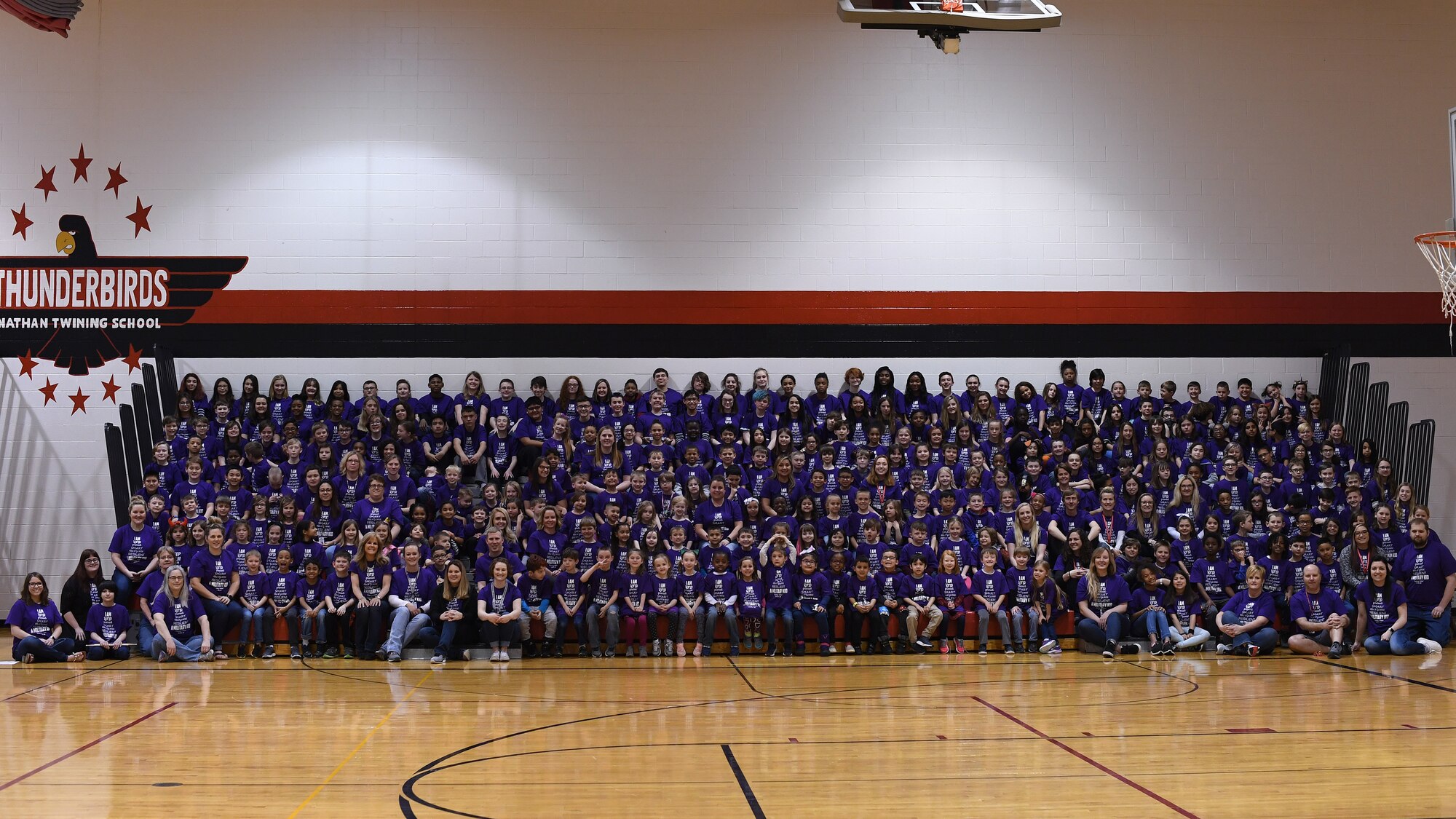 Students and staff gather for a group photo April 5, 2019, in Nathan Twining Elementary and Middle School on Grand Forks Air Force Base, North Dakota. The group photo was followed by a Month of the Military Child school rally, which included an awards presentation, band performance and ice cream social. (U.S. Air Force photo by Senior Airman Elora J. Martinez)
