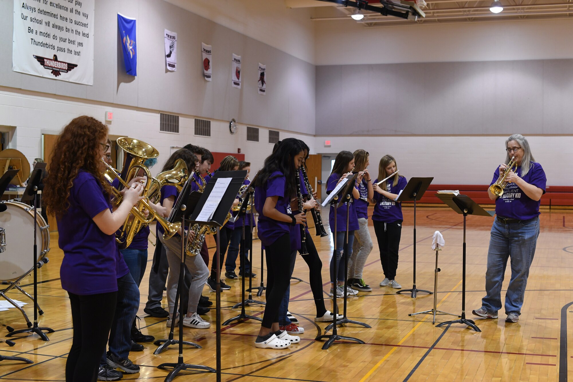 Students in the school band are led in a rendition of Queen’s “We Will Rock You” during a rally April 5, 2019, in Nathan Twining Elementary and Middle School on Grand Forks Air Force Base, North Dakota. Students and staff gathered together for a Month of the Military Child celebration, which acknowledged all the children’s hard work and rewarded them with an ice cream social. (U.S. Air Force photo by Senior Airman Elora J. Martinez)