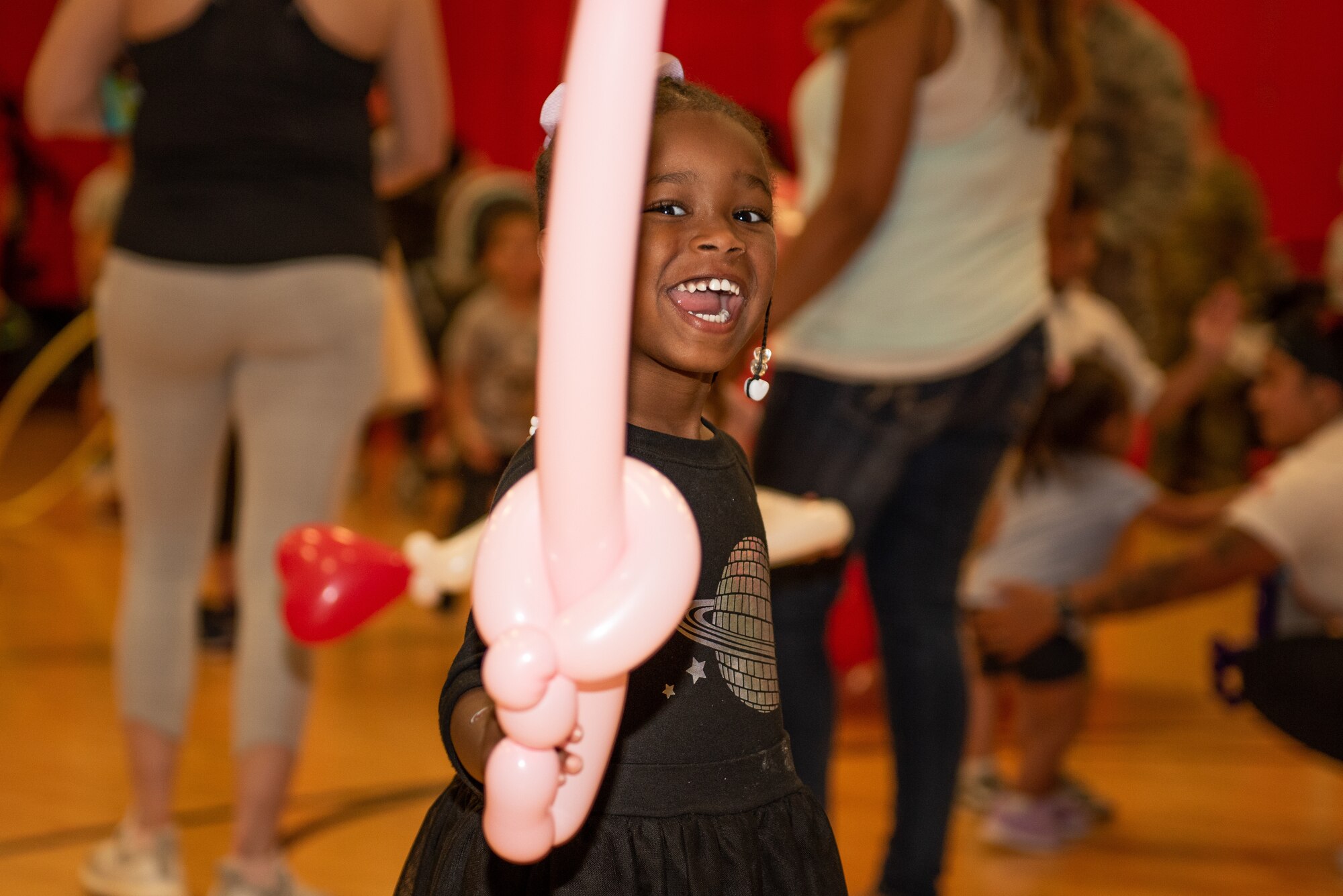 A child poses with her balloon sword at the Month of the Military Child Celebration at Luke Air Force Base, Ariz., April 5, 2019. The event was held to recognize and celebrate military children and their sacrifices while their parents or guardians are serving. (U.S. Air Force photo by Airman 1st Class Leala Marquez)