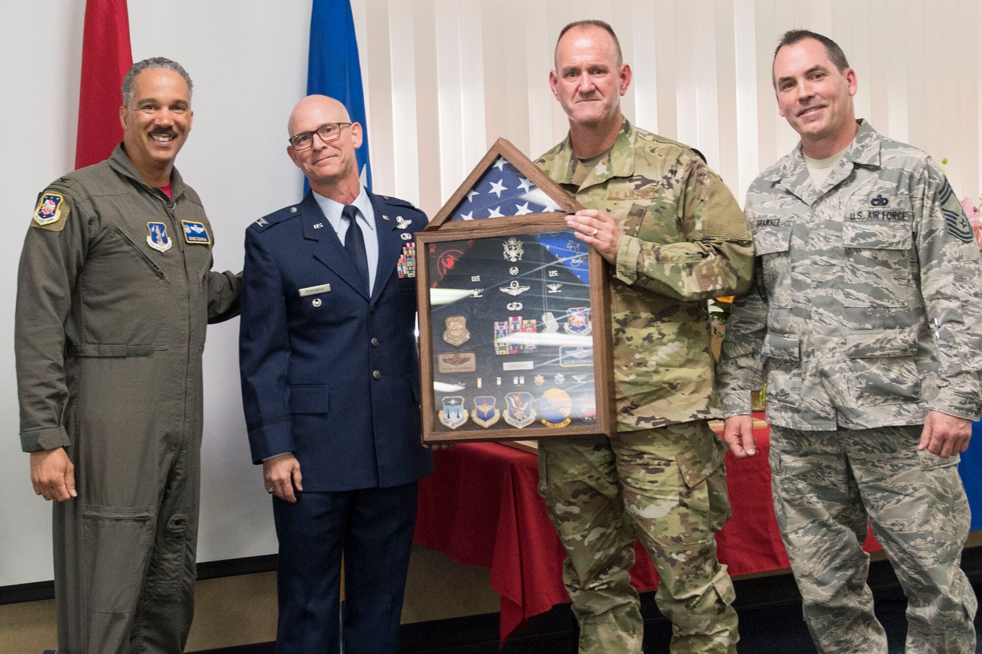 Col. David Cochran, 167th Airlift Wing Commander, left, West Virginia Air National Guard Command Chief Master Sgt. David Stevens, second from right, and 167th AW Command Chief Troy Brawner, right, presented Col. Shaun Perkowski a shadow box at his retirement ceremony. Perkowski was the 167th AW commander from October 2013- October 2018. (U.S. Air National Guard photo by Tech. Sgt. Jodie Witmer)