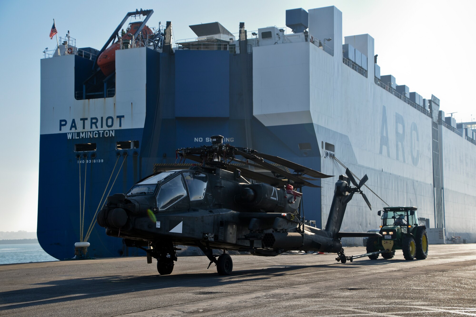 An AH-64D Apache helicopter is taken off a ship at Naval Station Rota, Spain, during helicopter intermodal operations. This operation uses multiple modes of transportation to reduce cargo handling, improve security, minimize damage and allow quicker freight transportation. (U.S. Navy photo by Mass Communication Specialist 1st Class Benjamin A. Lewis)
